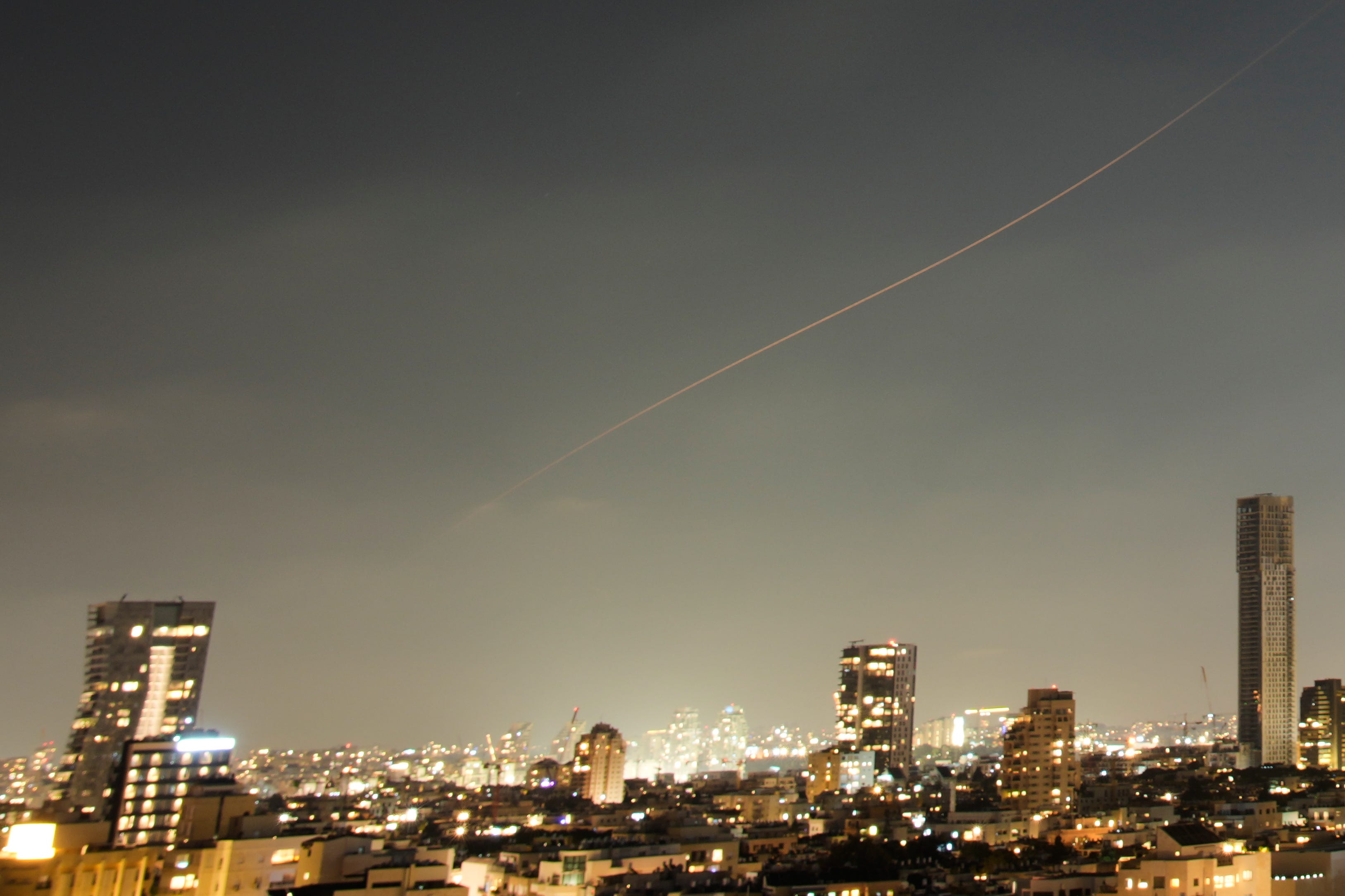 A projectile streaks through the sky over central Israel during an Iranian missile attack (Ohad Zwigenberg/AP)