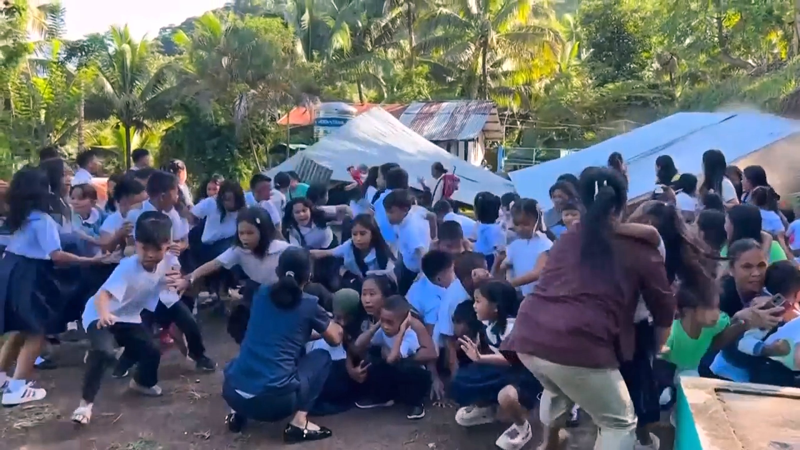 Children react as a canopy roof collapses due to the earthquake in Malita, Davao Occidental province, on 8 June 2026