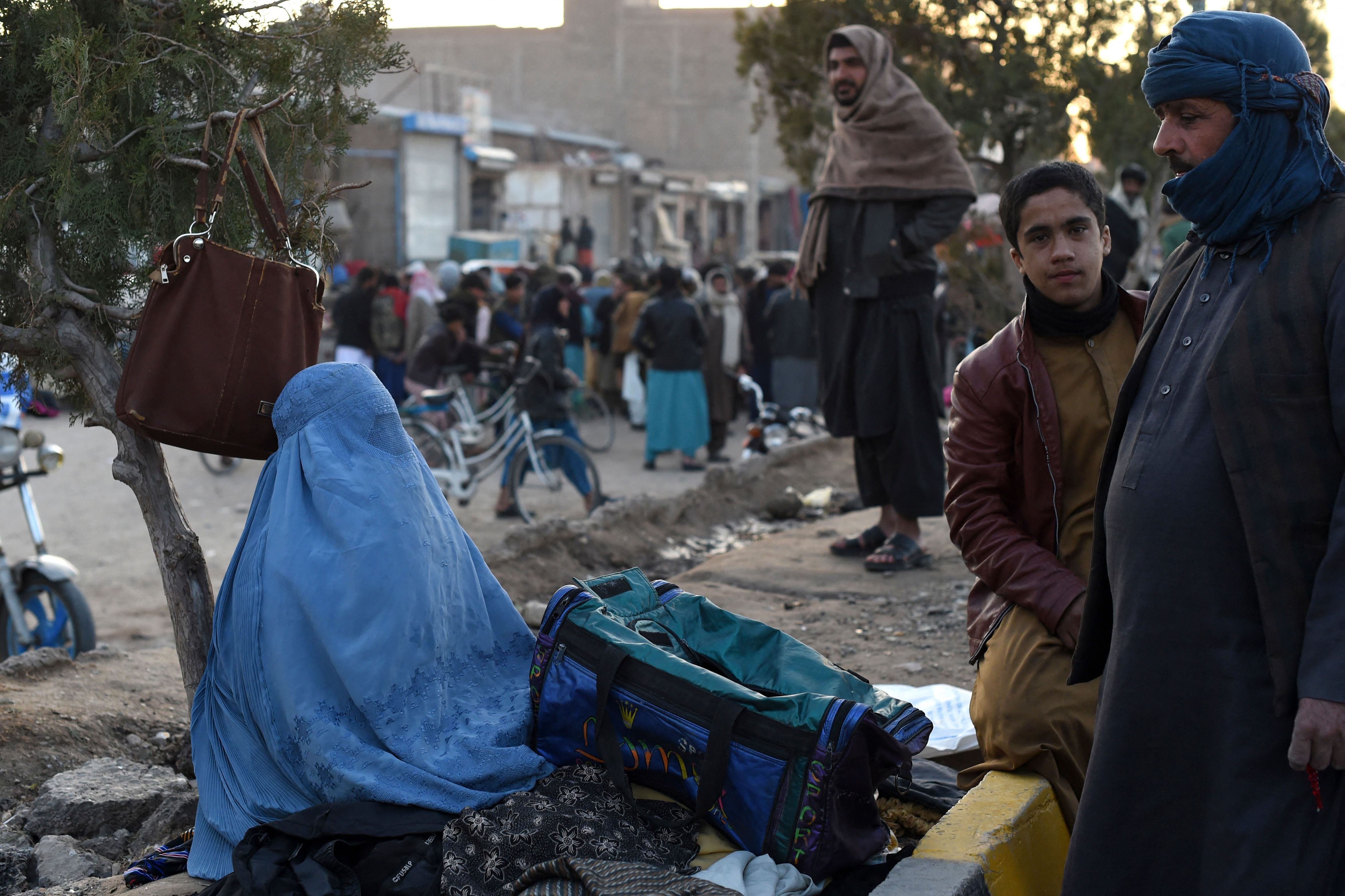 A woman wearing a burqa at a market in Herat in 2022