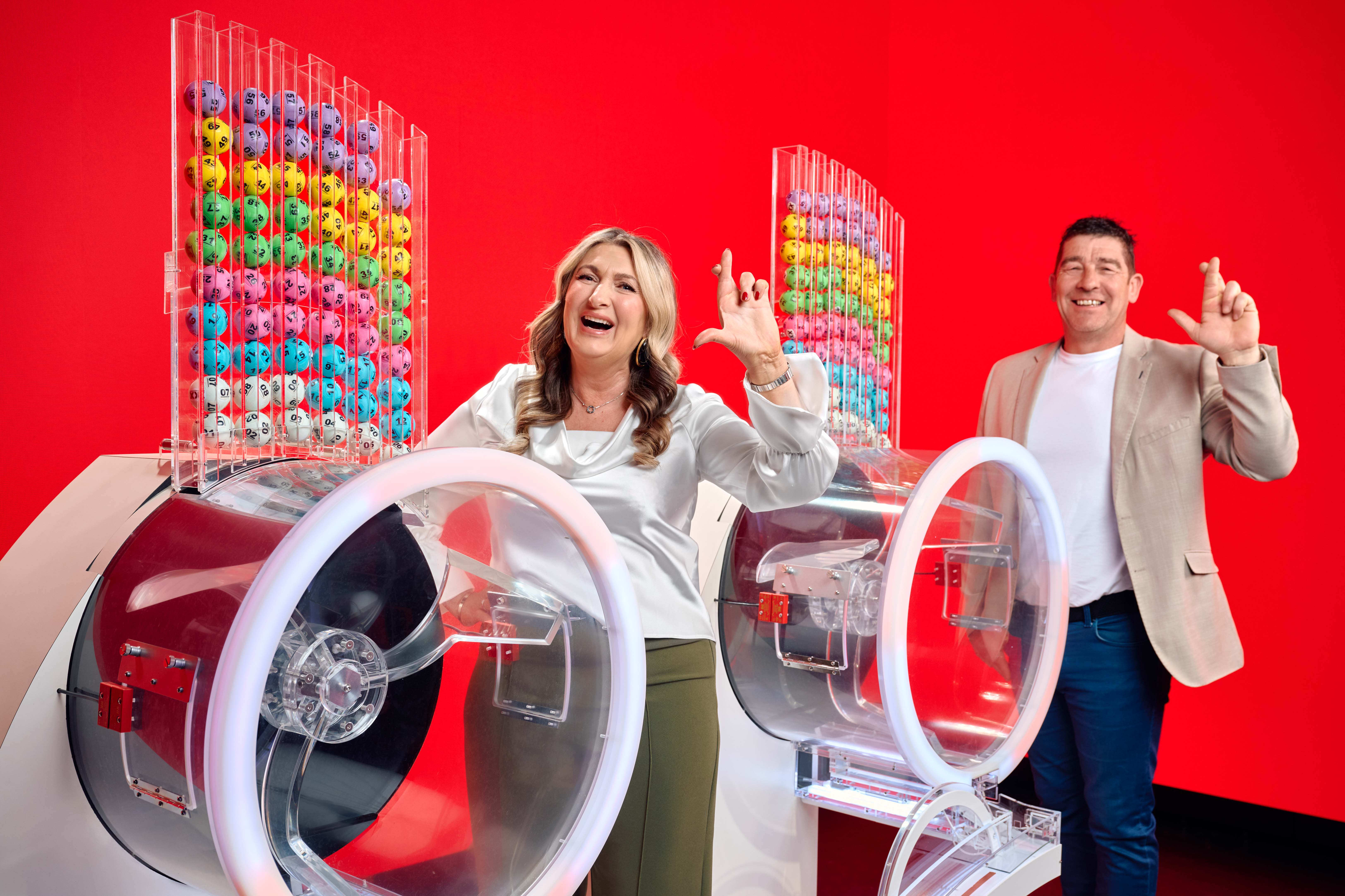 Chris and Geraldine Bradley, who won £3.57 million in the Lotto in 2006, with two Lotto draw machines to mark the new two-round format