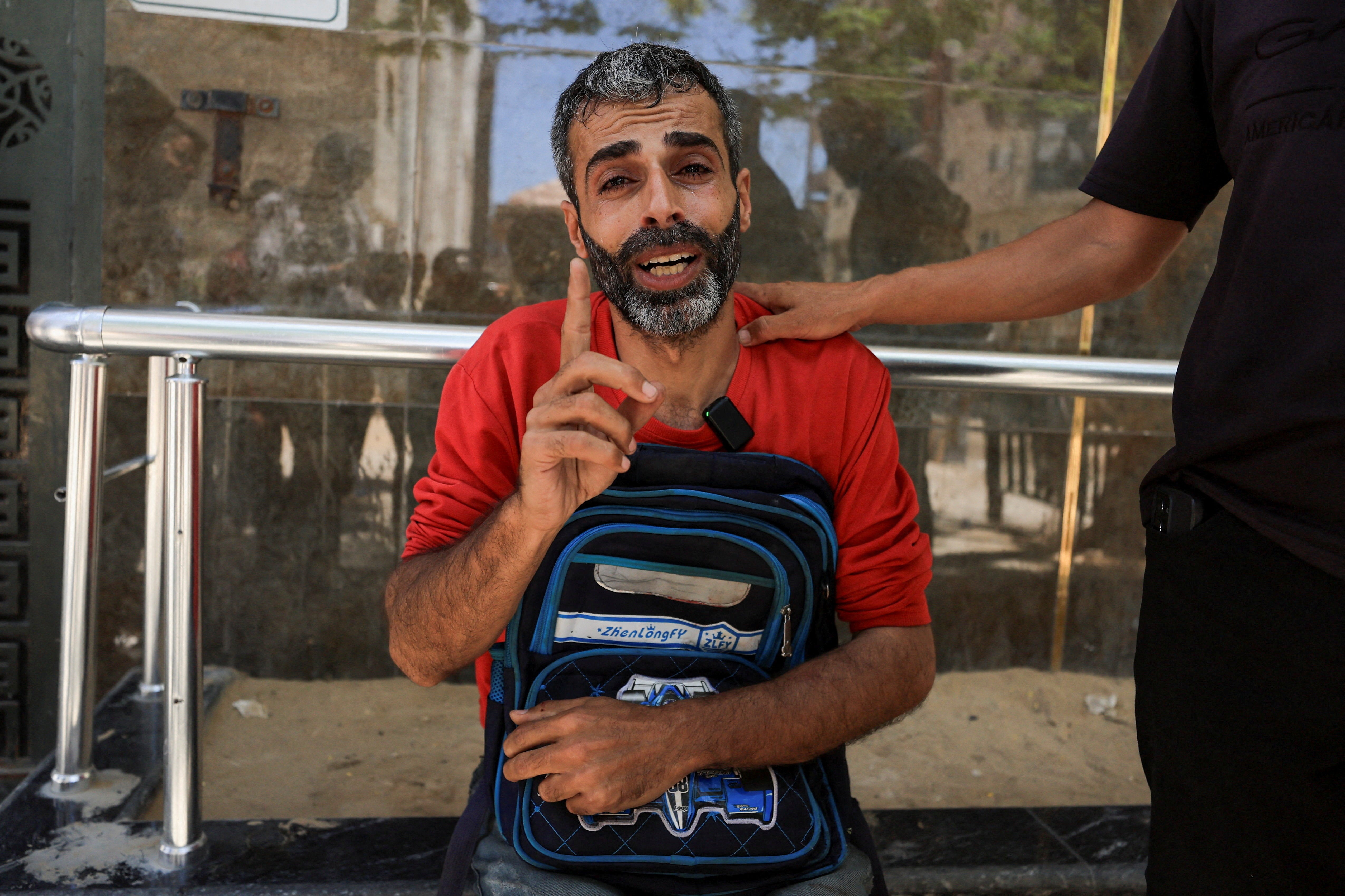 Palestinian father Youssef Salman mourns as he carries the school bag of his eight-year-old son Jad, who was killed in an Israeli strike on the Jabalia refugee camp (Reuters)