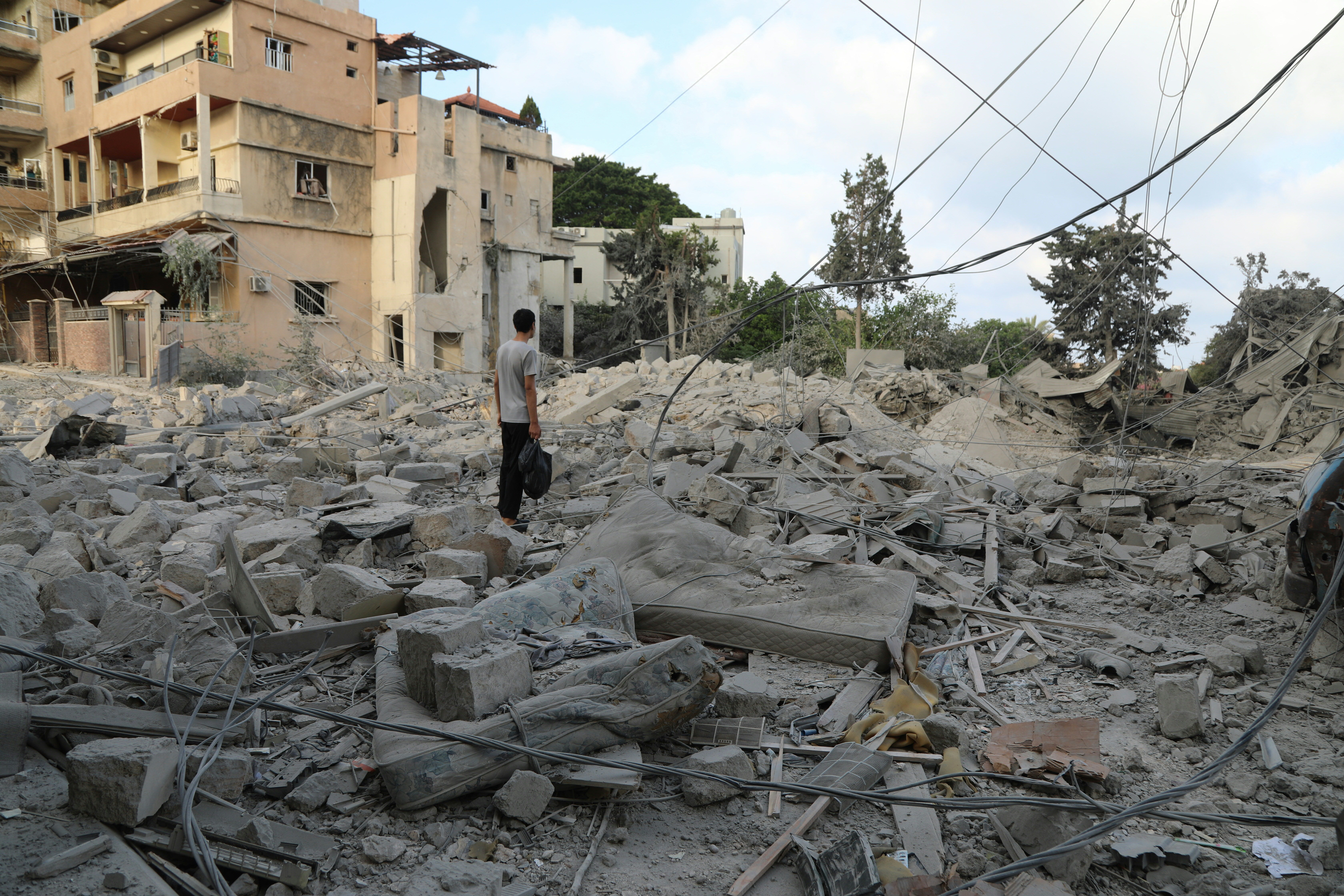 A man stands amid debris following Israeli airstrikes that hit the previous day, near the archaeological site of the Roman baths in the southern Lebanese city of Tyre on June 8