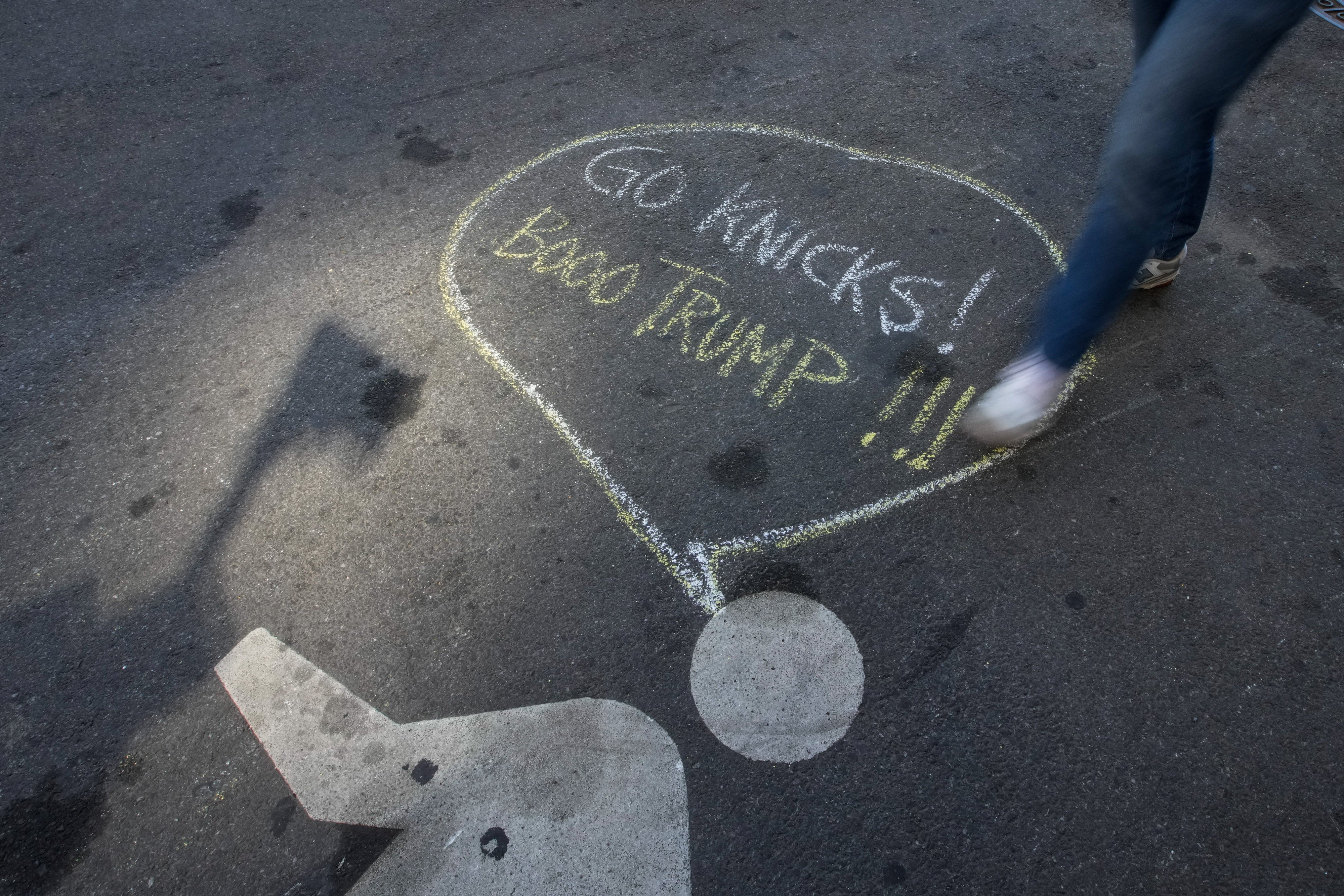 A chalk message outside Madison Square Garden that reads, 'Go Knicks! Booo Trump!!!' (REUTERS)