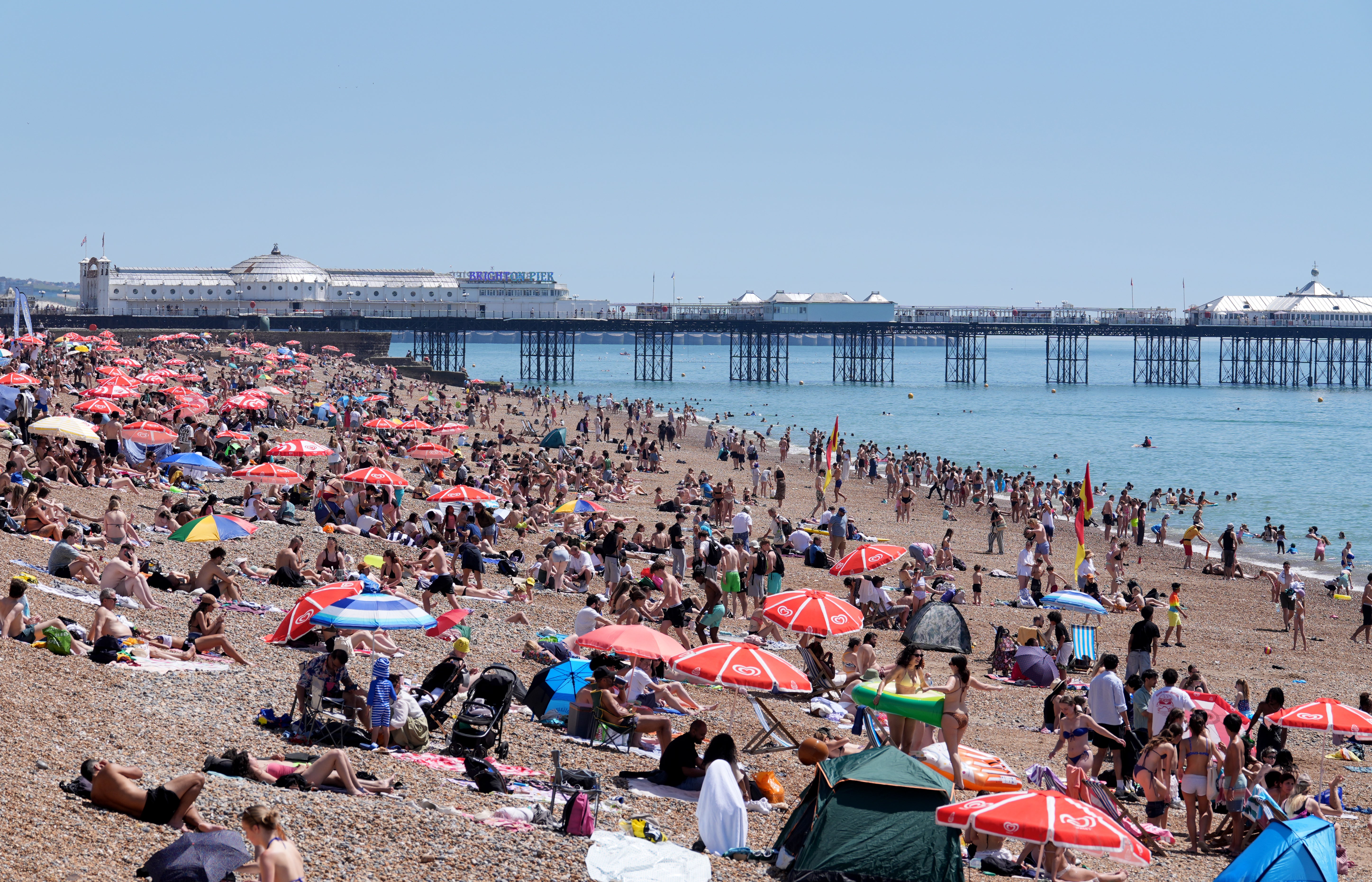 People enjoying the hot weather at the beach in Brighton, East Sussex (Gareth Fuller/PA)