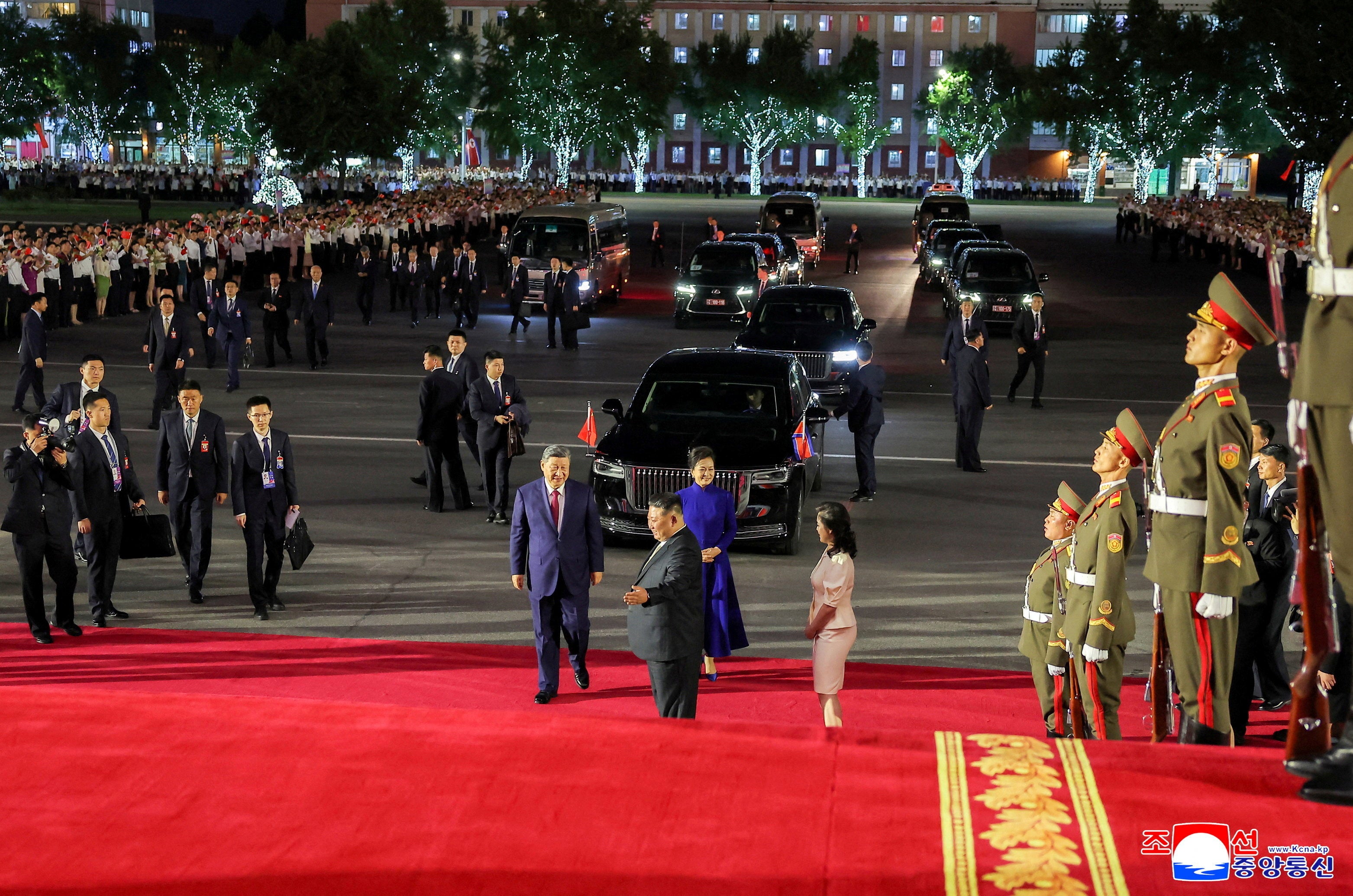 Chinese President Xi Jinping, his wife Peng Liyuan, North Korean leader Kim Jong Un, and his wife Ri Sol Ju together on a red carpet as they attend a performance at the Pyongyang Indoor Stadium, during Xi's state visit, in Pyongyang, North Korea