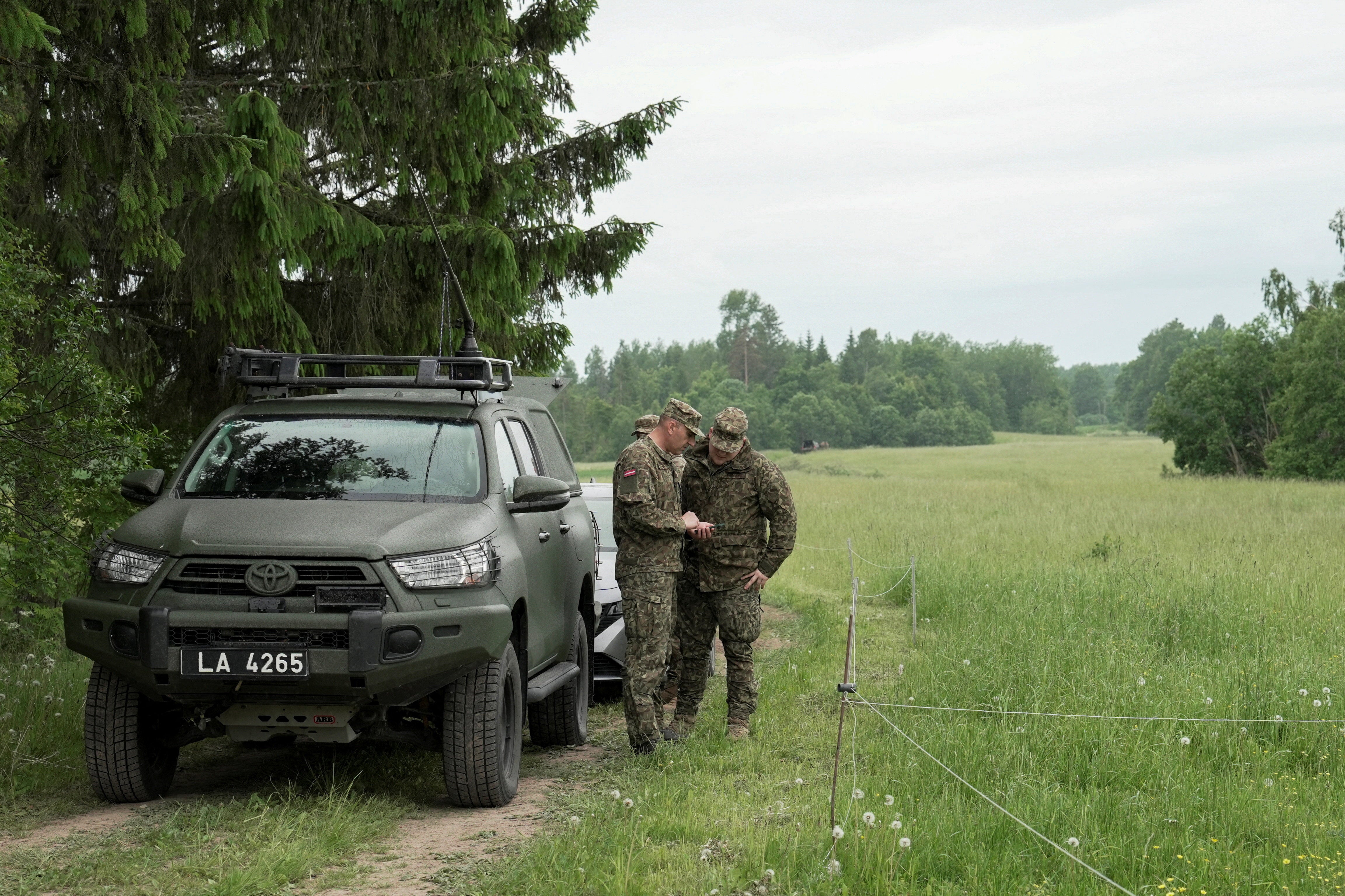 Servicemen of the Latvian National Guard search for the debris from an intercepted drone in Rogovka in Latvia (Reuters)