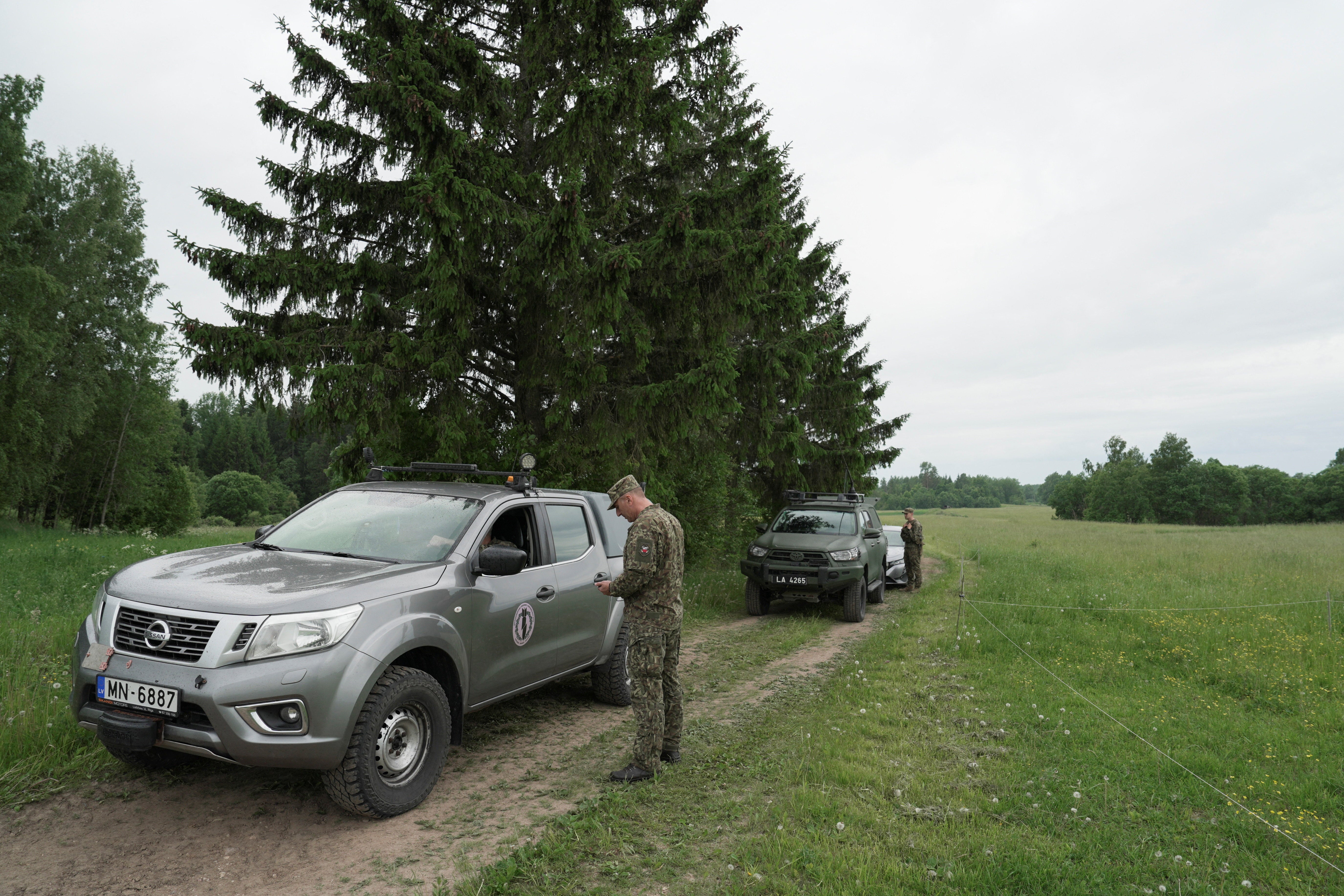 Military vehicles on a countryside road during a search for the debris from an intercepted drone in Rogovka, Latvia (Reuters)