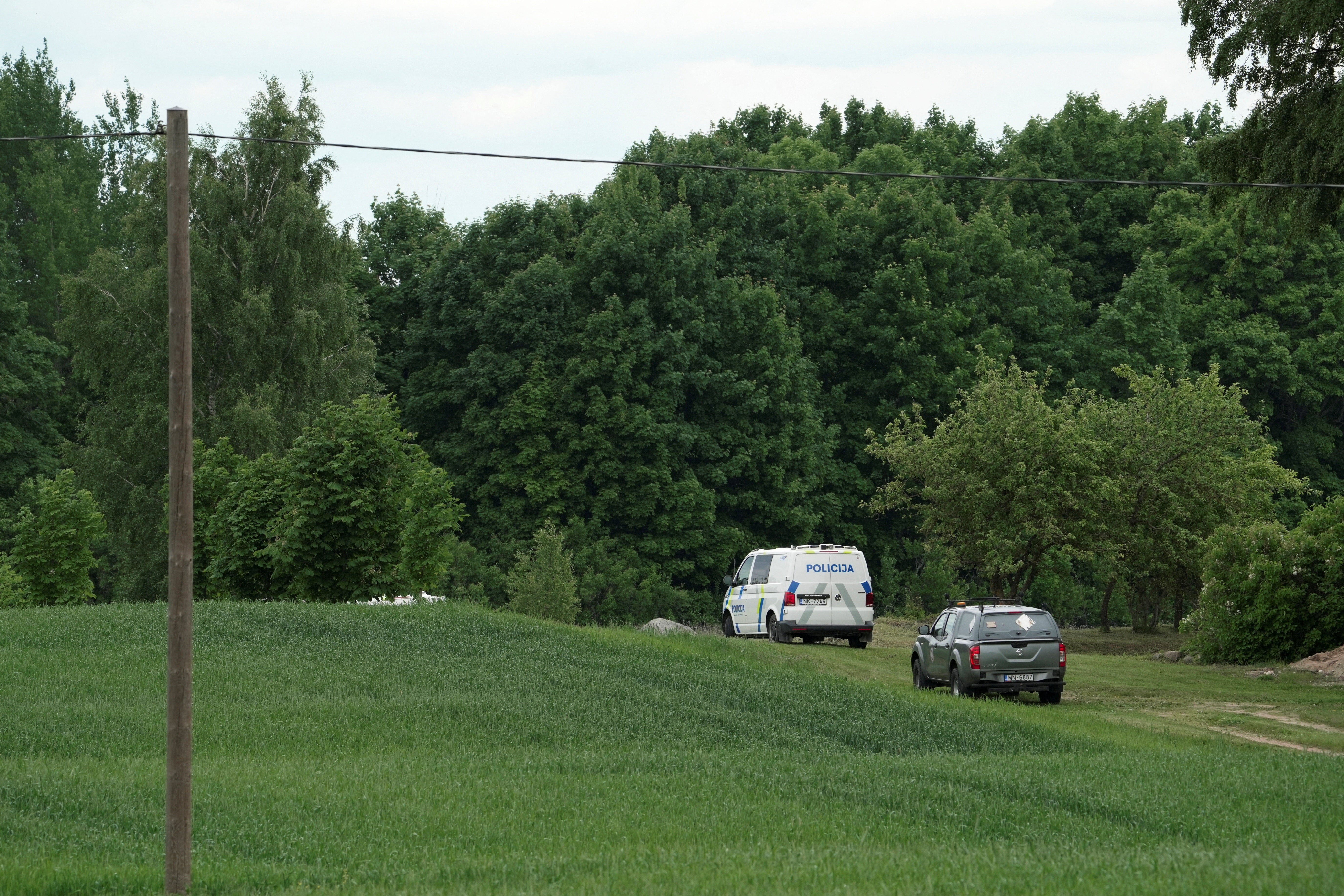 A police vehicle on a field during a search for the debris from an intercepted drone in Rogovka (Reuters)