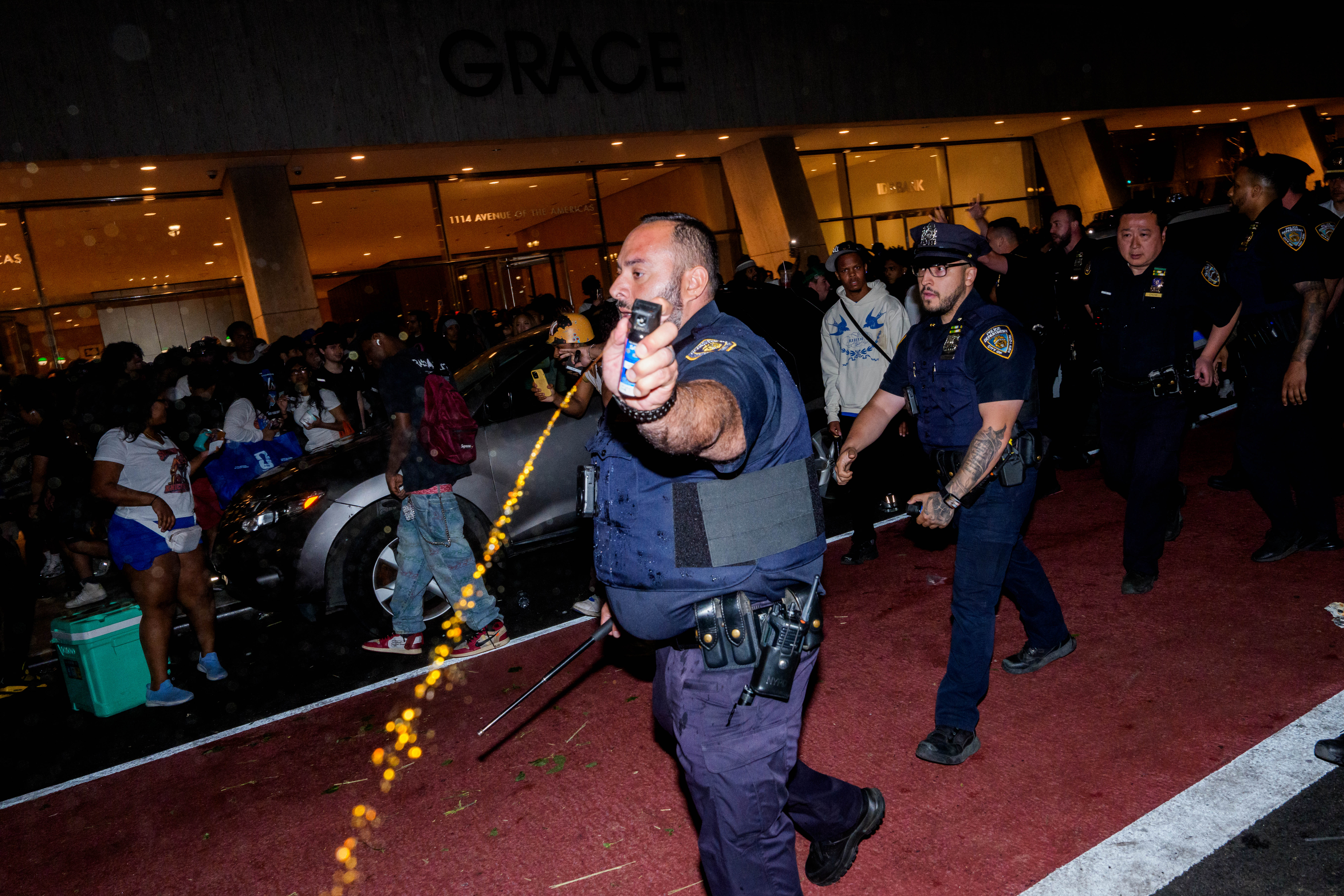 An NYPD officer uses pepper spray as New York Knicks fans clash with officers (Getty)