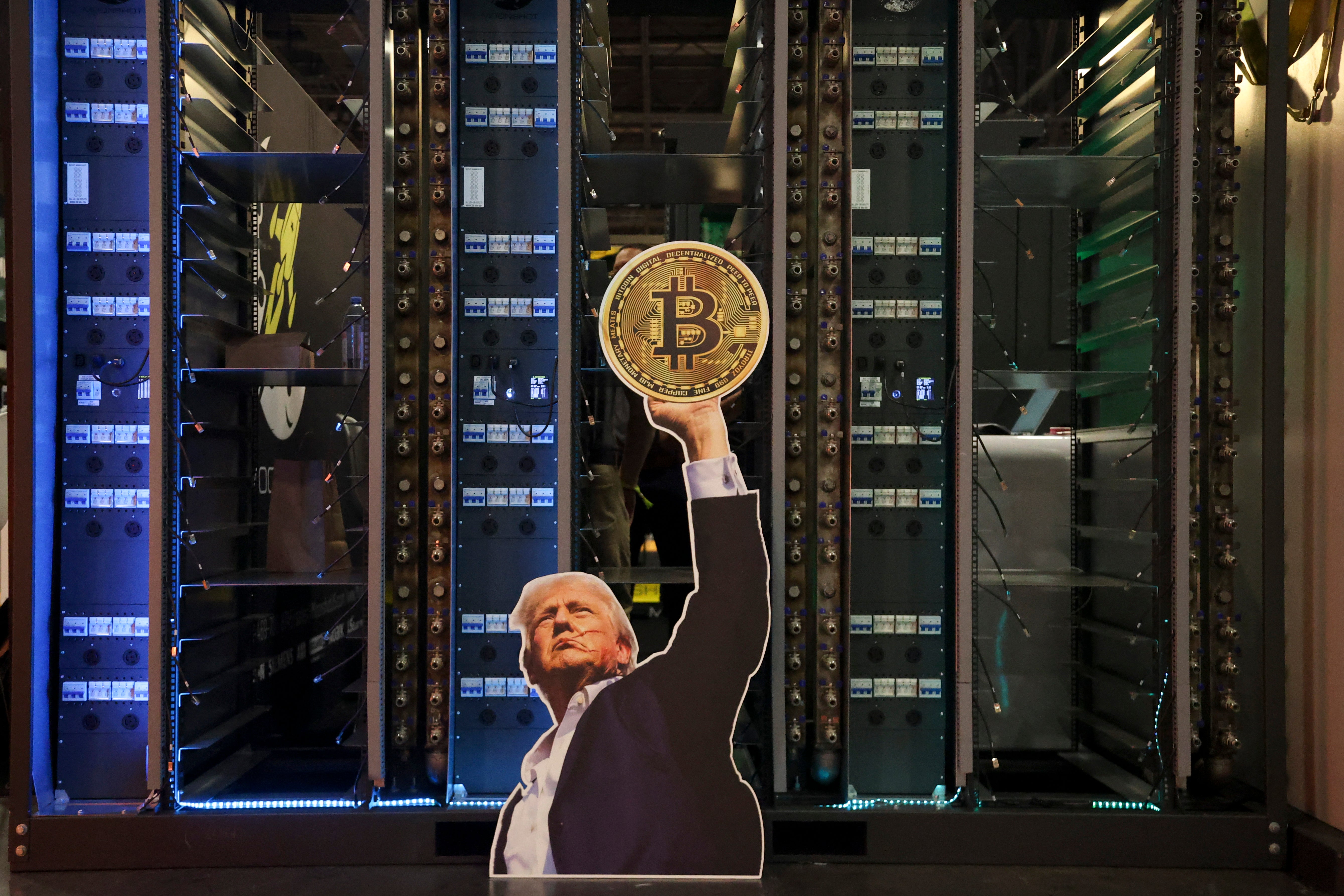 A cutout of President Donald Trump holding a Bitcoin is displayed in front of computer servers during The Bitcoin Conference in Las Vegas, on May 27, 2025