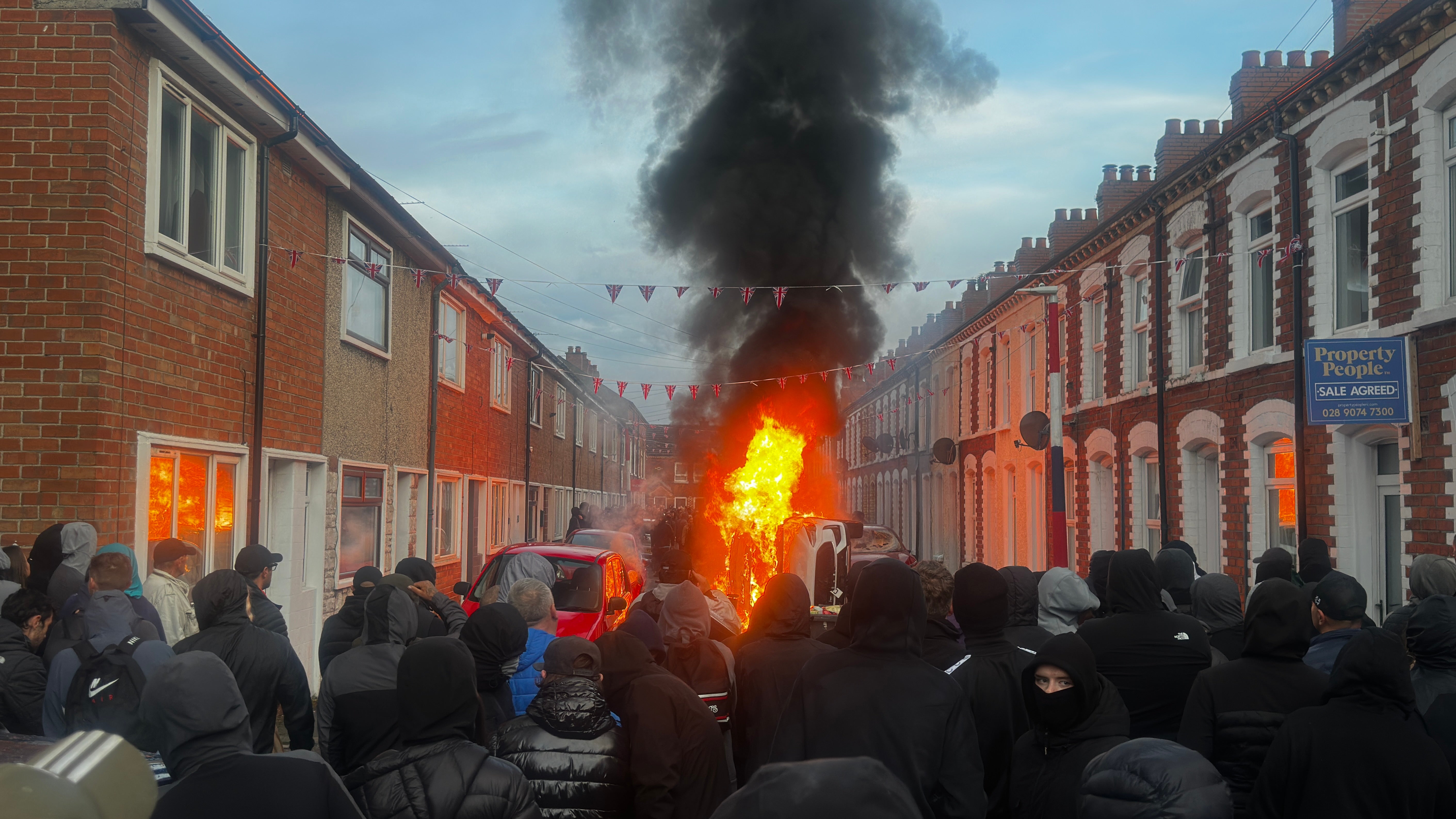 Vehicles set on fire by protesters on Lendrick Street in Belfast (PA)
