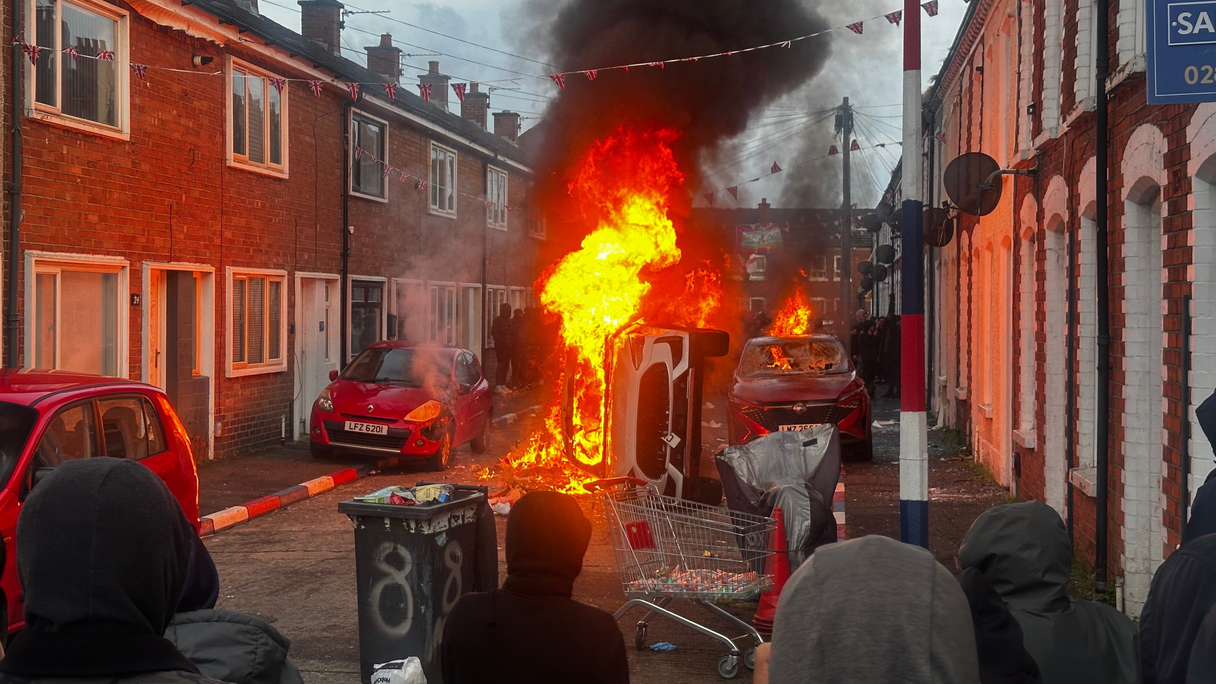 Vehicles set on fire by protesters on Lendrick Street in Belfast (PA)