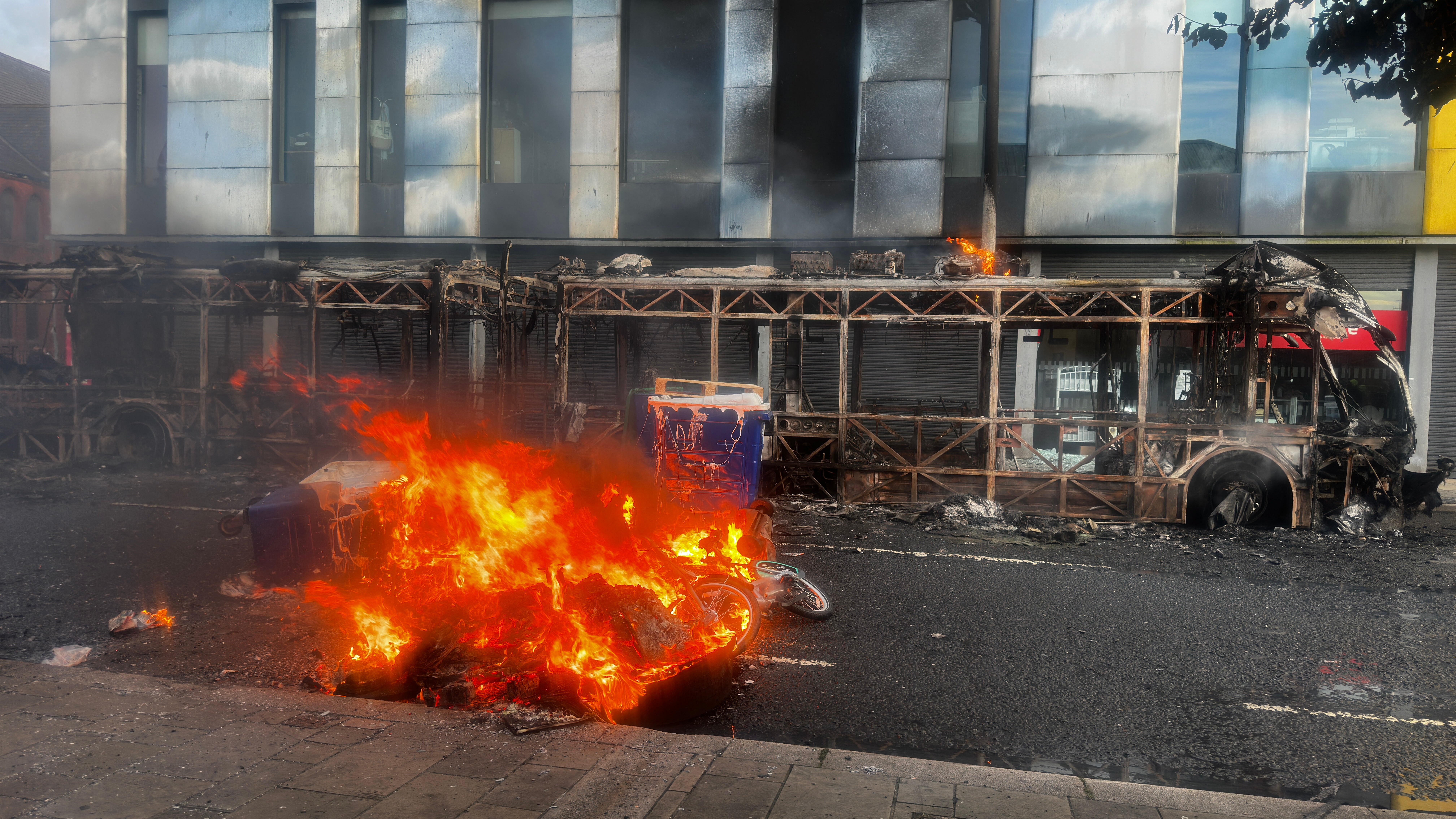 The skeleton of a Glider bus, set on fire by protesters, on the Newtownards Road in east Belfast