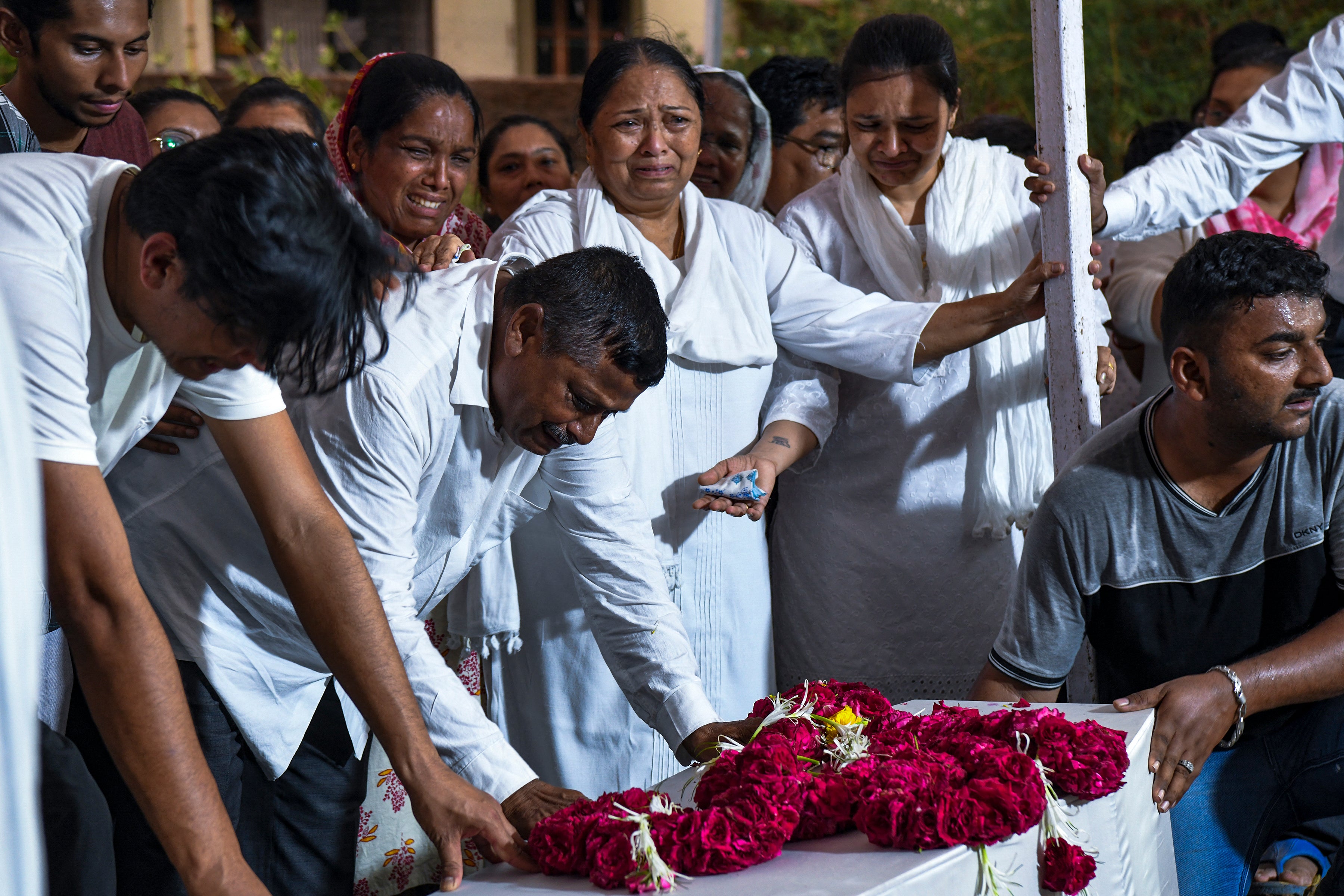 Relatives grieve over Rozar David Christian and his wife Rachnaben Rozar Christian, both victims of the Air India crash, during their funeral in Ahmedabad