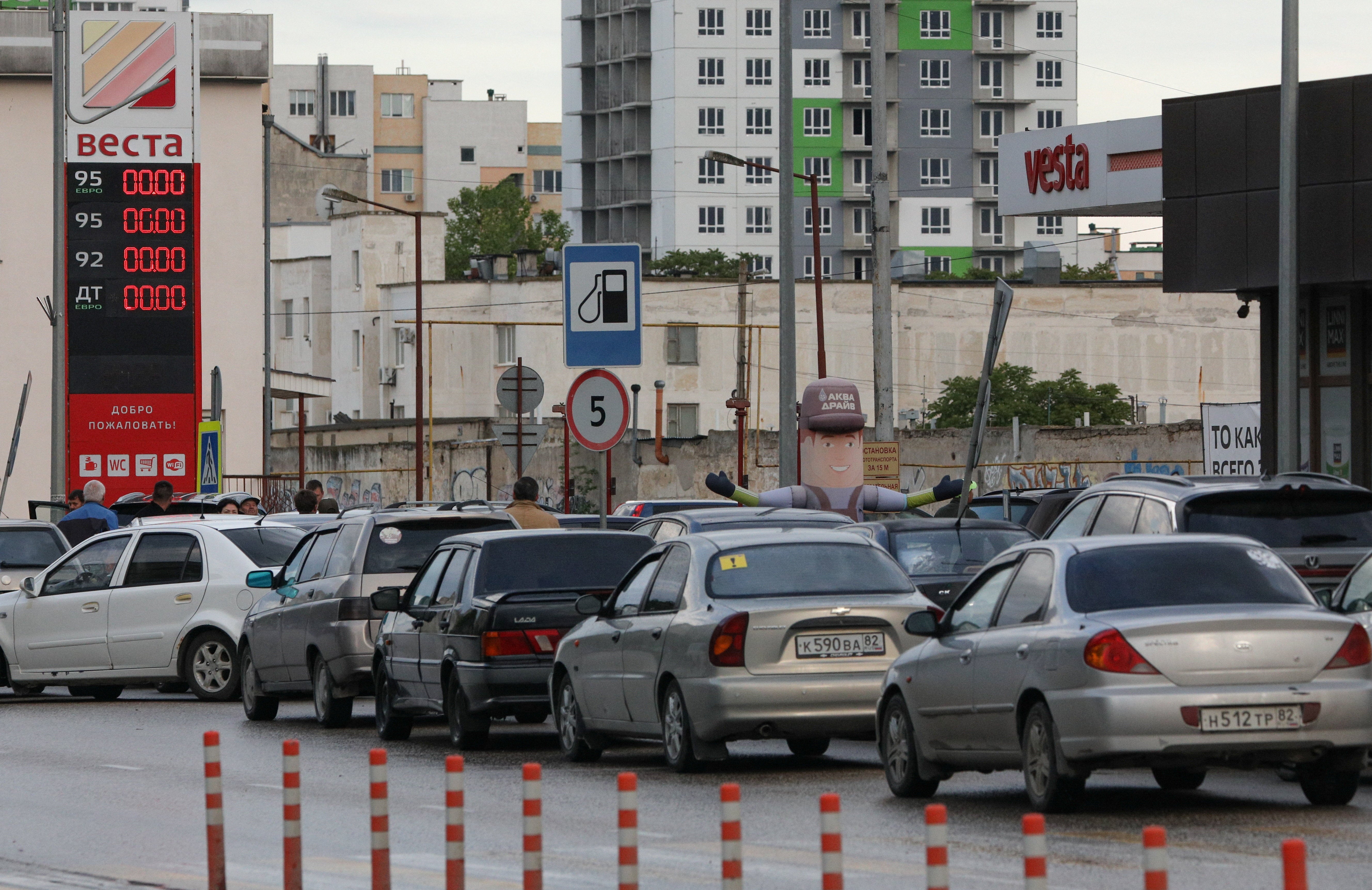 Cars queue for fuel at a gas station after the authorities restricted fuel sales amid a supply shortage in the Black Sea resort city of Yevpatoriya (Reuters)