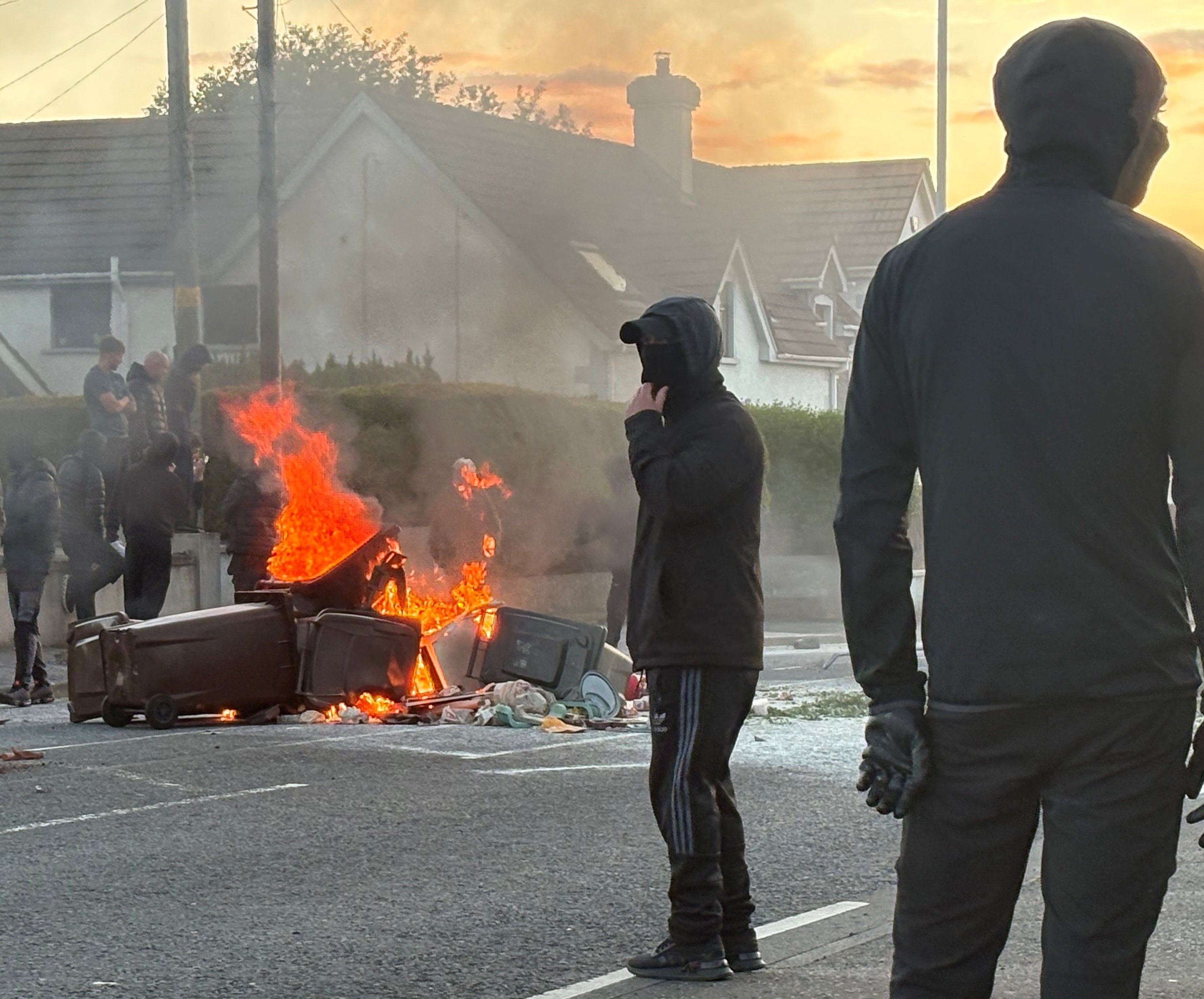 A fire burns in bins as protesters clash with police at Antrim Road