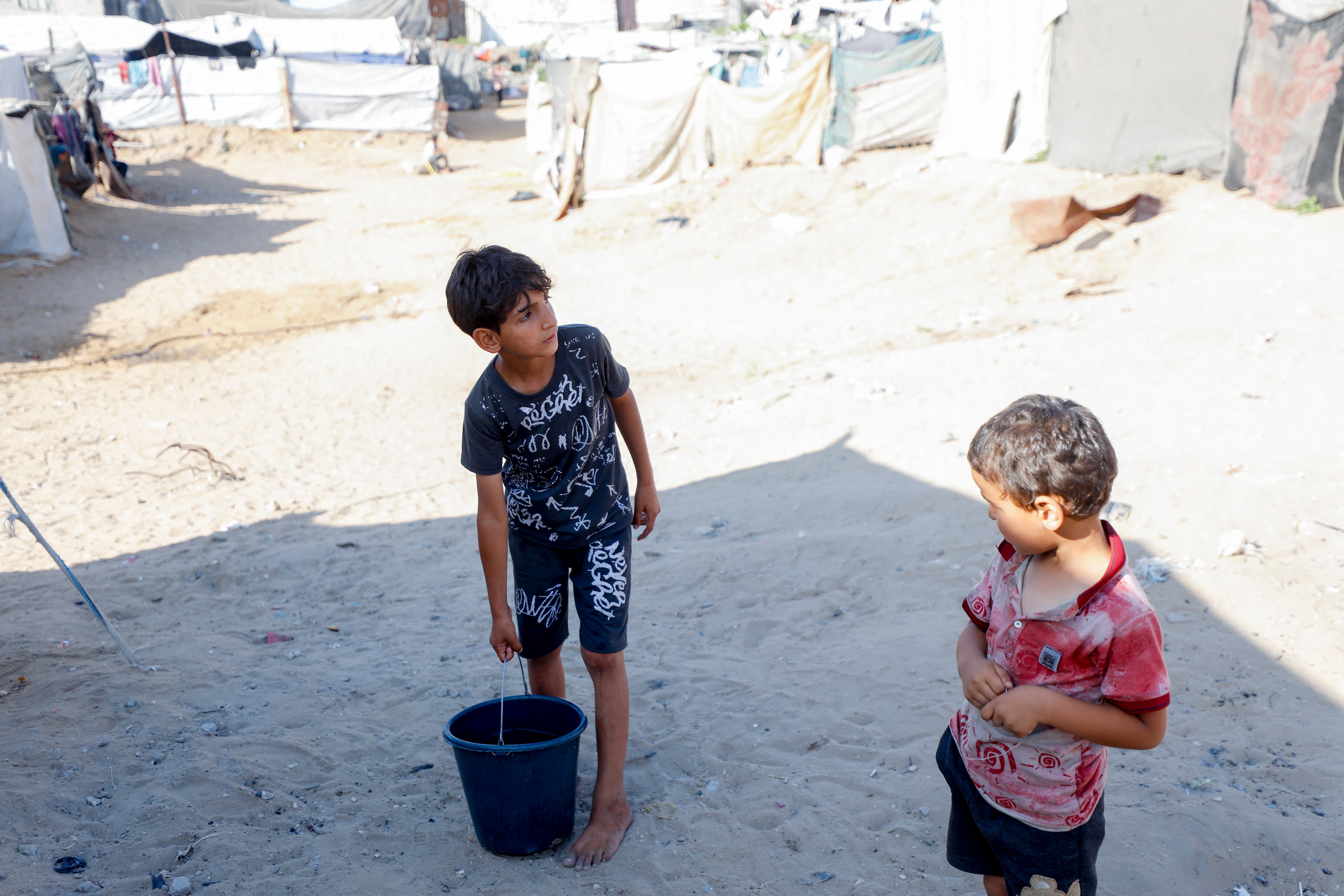 Children displaced by Israel's war on Gaza stand near their tents on 10 June 2026
