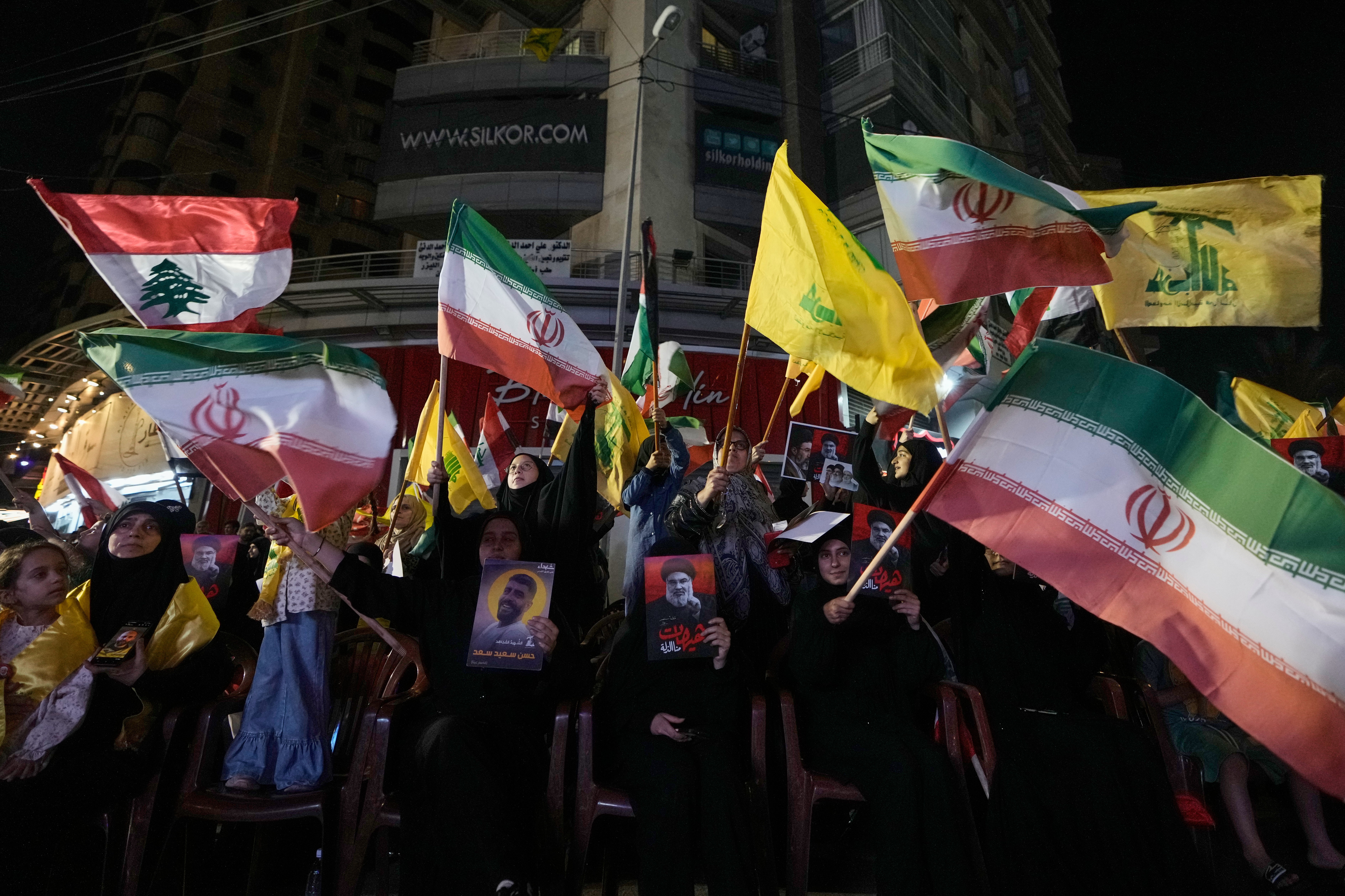 Hezbollah supporters wave their own and Iranian national flags during a gathering against the American-Israeli military operation with Iran and its allies in Dahiyeh, Lebanon (AP)