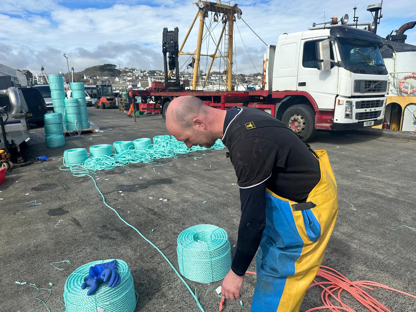 A member of Mr. Carroll's crew repairs rope damaged by crab pots