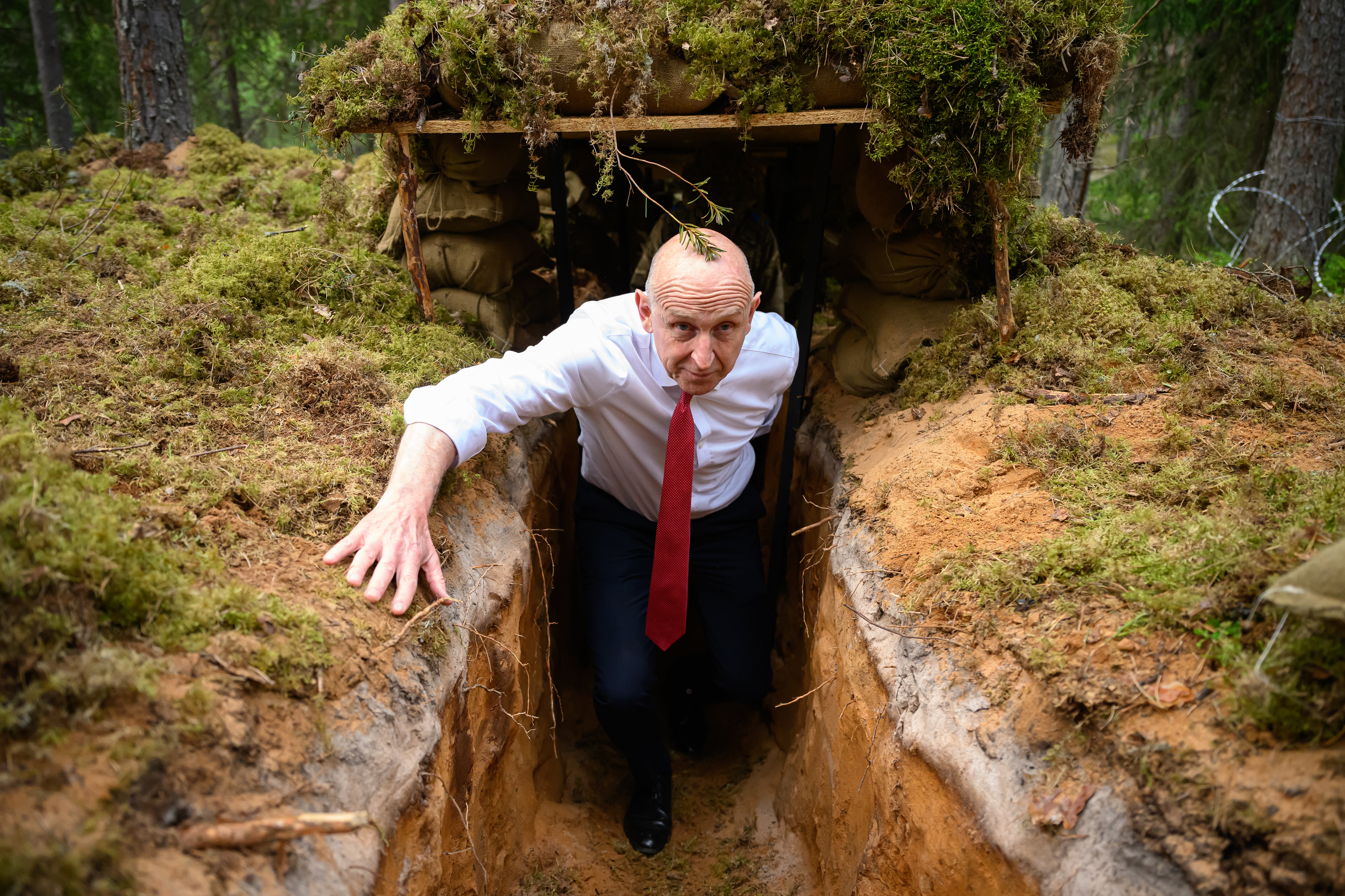 John Healey emerges from a trench after being shown around as British personnel participate in Exercise Spring Storm on 21 May 2026