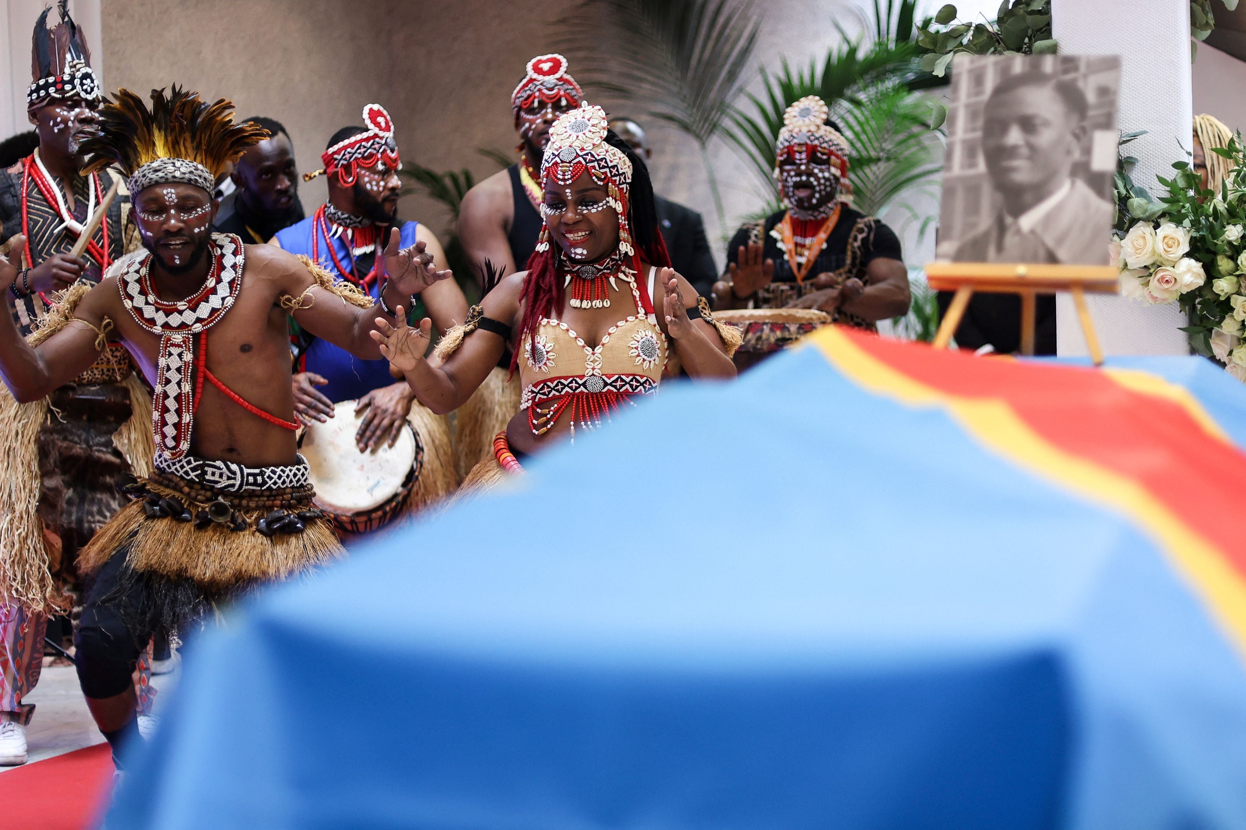 Dancers perform next to the coffin of Democratic Republic of Congo's first prime minister and independence hero Patrice Lumumba during a tribute ceremony at The Congolese Embassy before the departure of his last remains to the DRC in Brussels in 2022 (AFP/Getty)