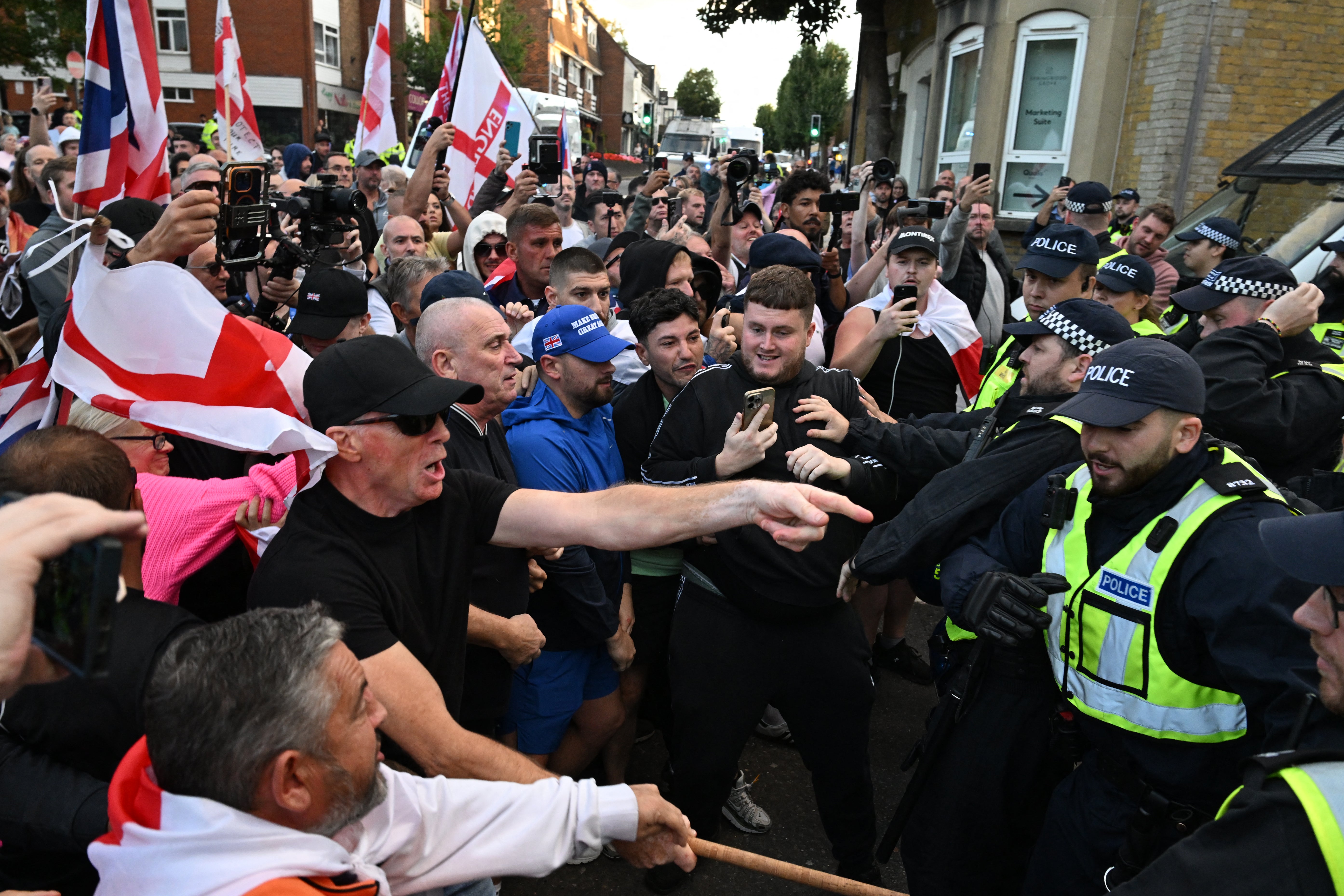 Police officers and protesters scuffle outside the council offices in Epping after a march from the Bell Hotel which houses asylum seekers, northeast of London, on August 31, 2025. (AFP/Getty)