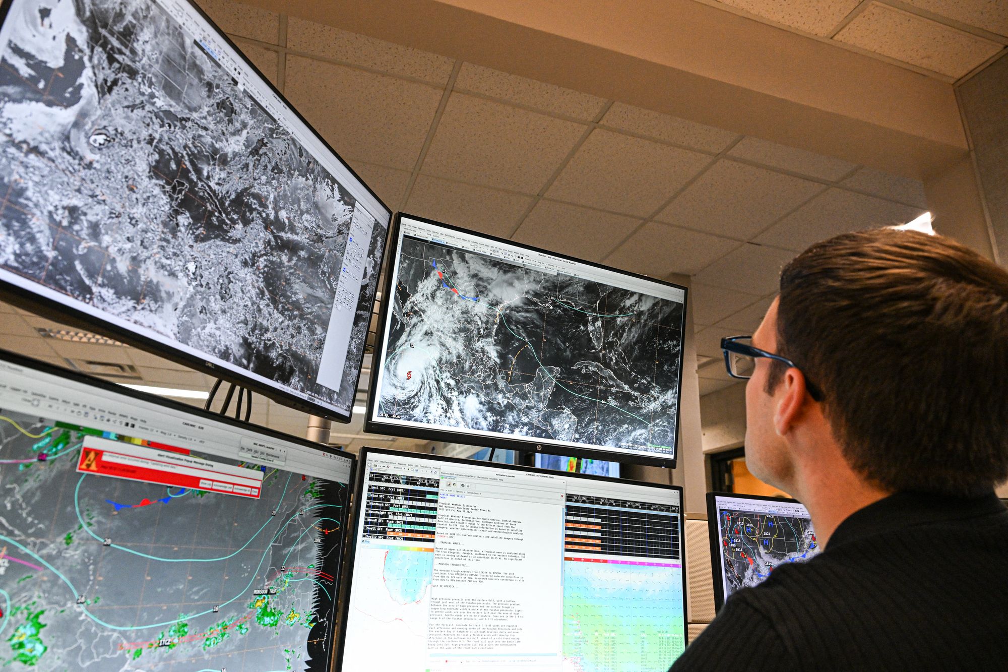 NOAA meteorologist Aidan Mahoney works at the National Hurricane Center in Miami, Florida, in May 2025. Scientists are still using traditional forecasting methods alongside AI models