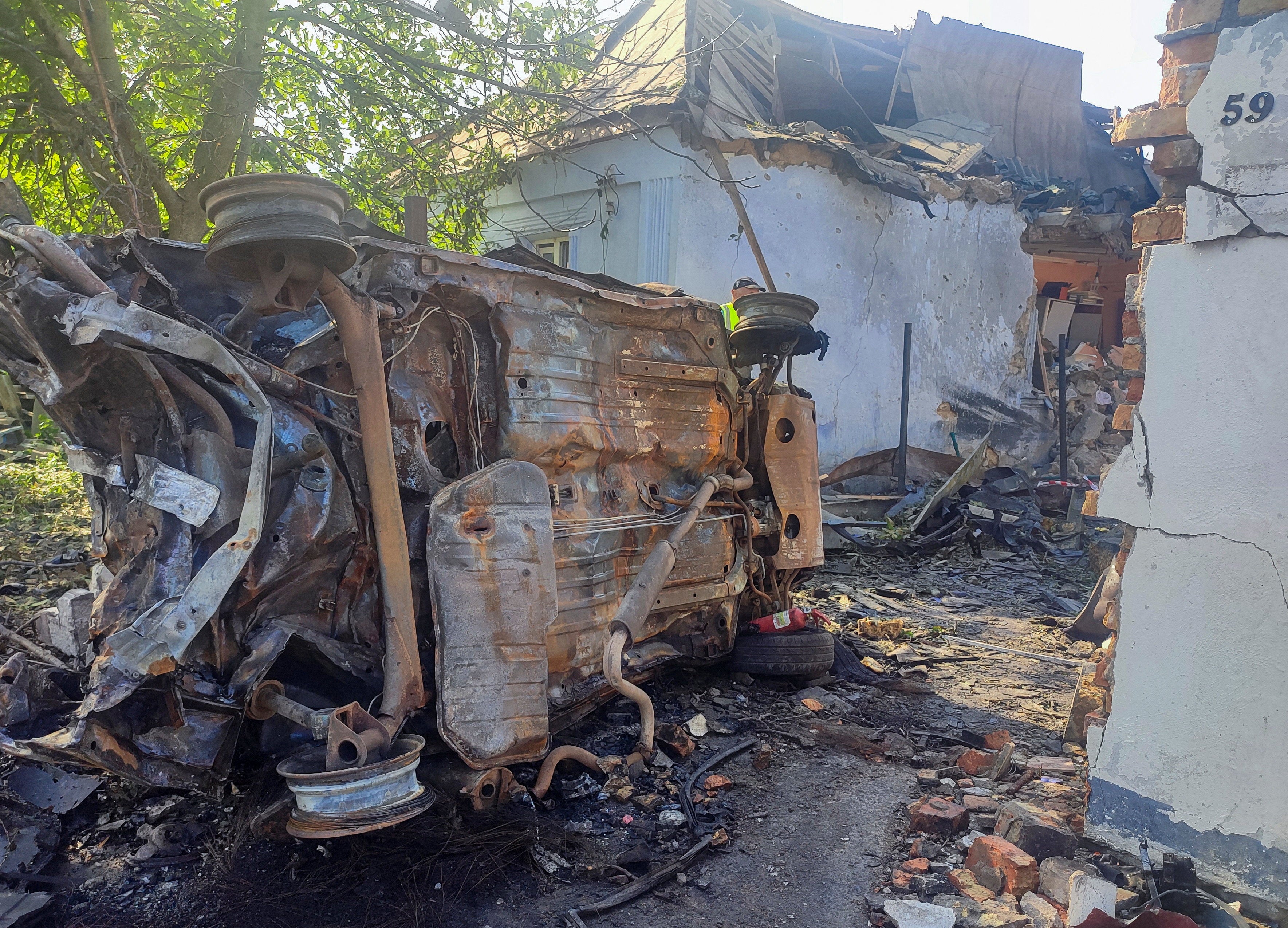 A destroyed car at a site where a house was heavily damaged by a Russian drone strike