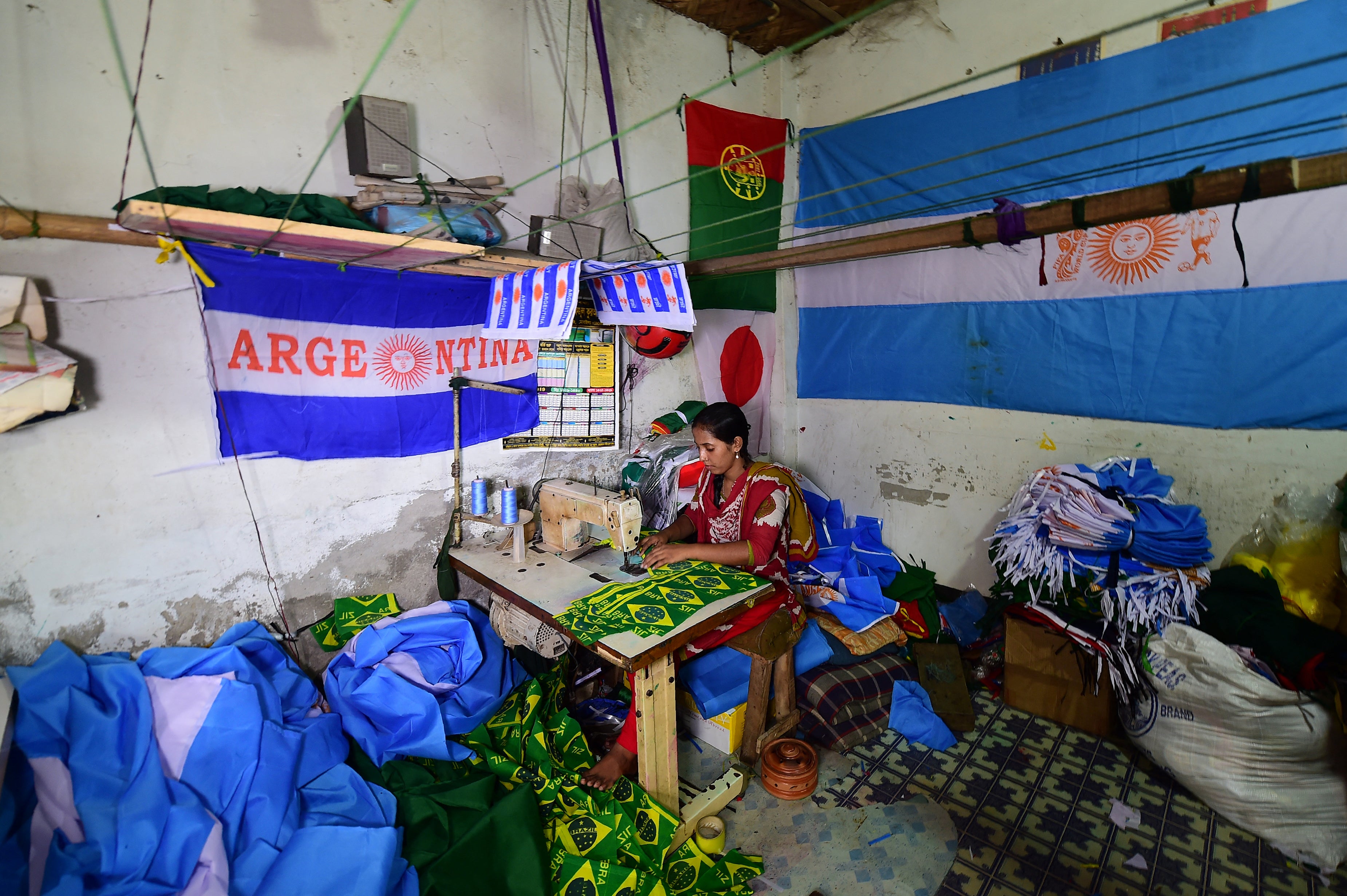 File: A Bangladeshi worker sewing flags for the World Cup football playing nations in Narayanganj, on the outskirts of Dhaka, ahead of the 2018 football World Cup (AFP via Getty Images)