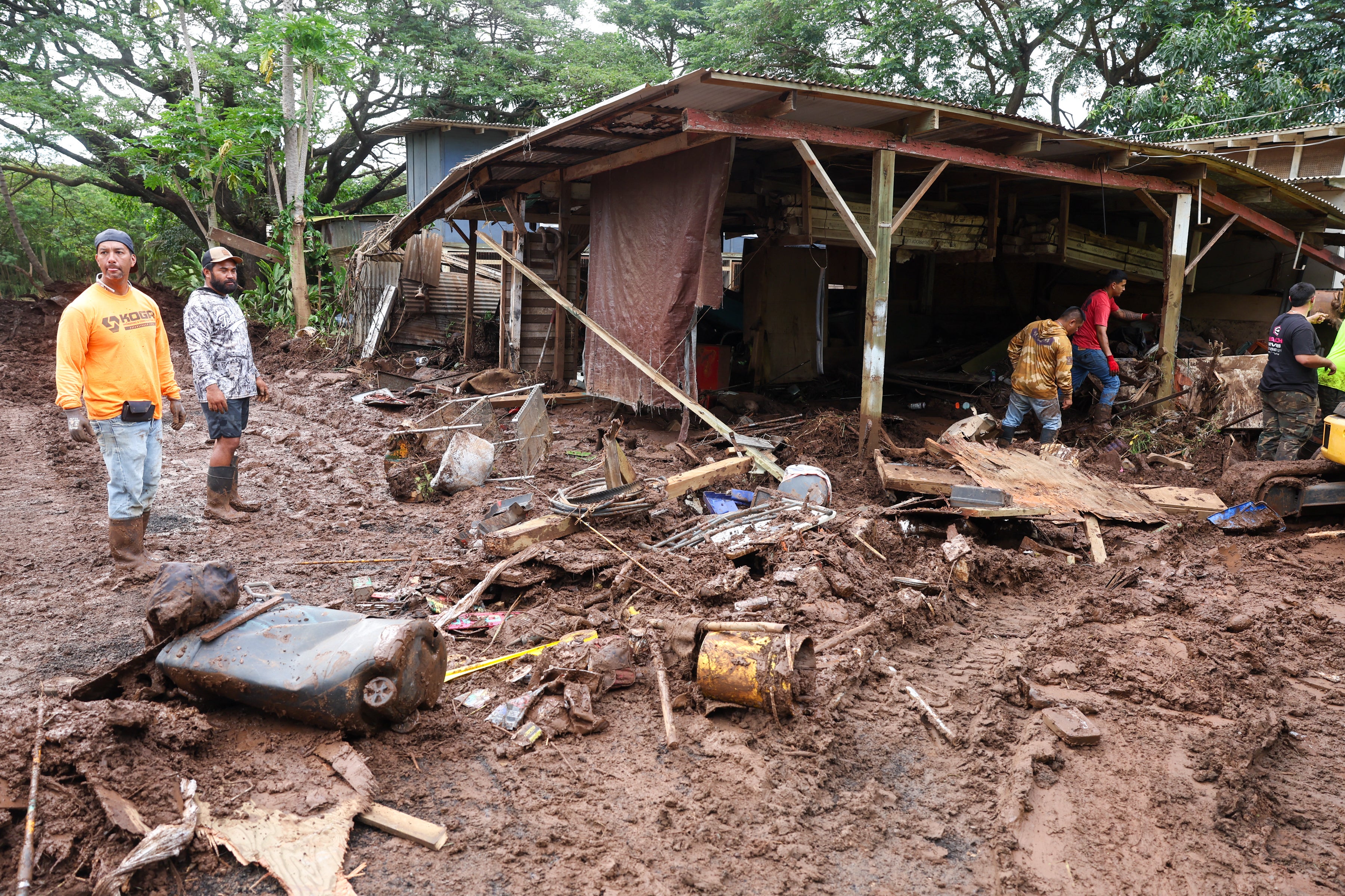 People in Waialua, Hawaii clear rubble in the aftermath of the Kona Low storm flood that hit the islands in March. Vrbo customer Steven Cavagnaro cancelled his Hawaii vacation home booking ahead of the storm, but was not refunded despite the unforeseen and severe weather (AFP/Getty)