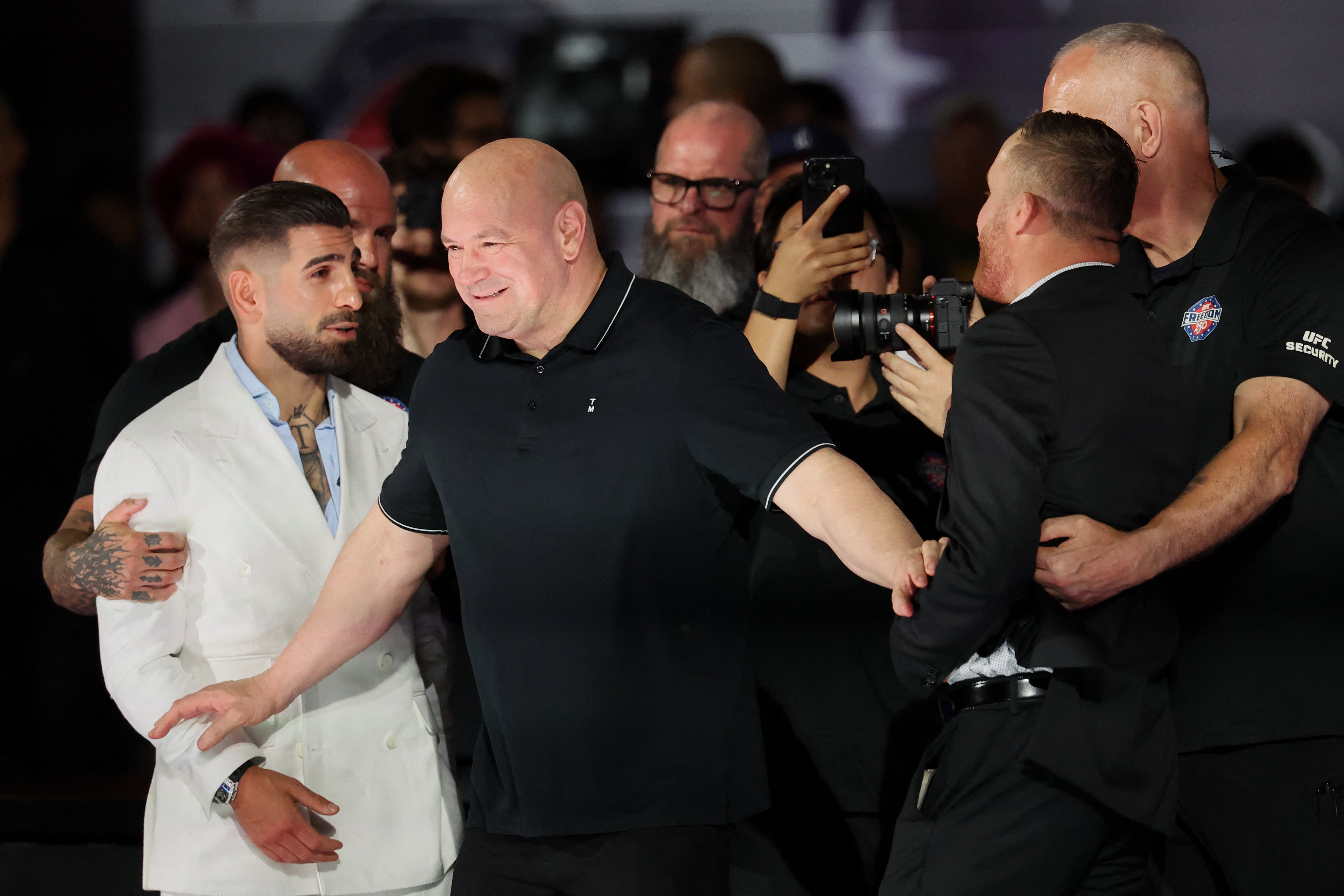 Justin Gaethje (right) and Ilia Topuria being held back from one another (Reuters)