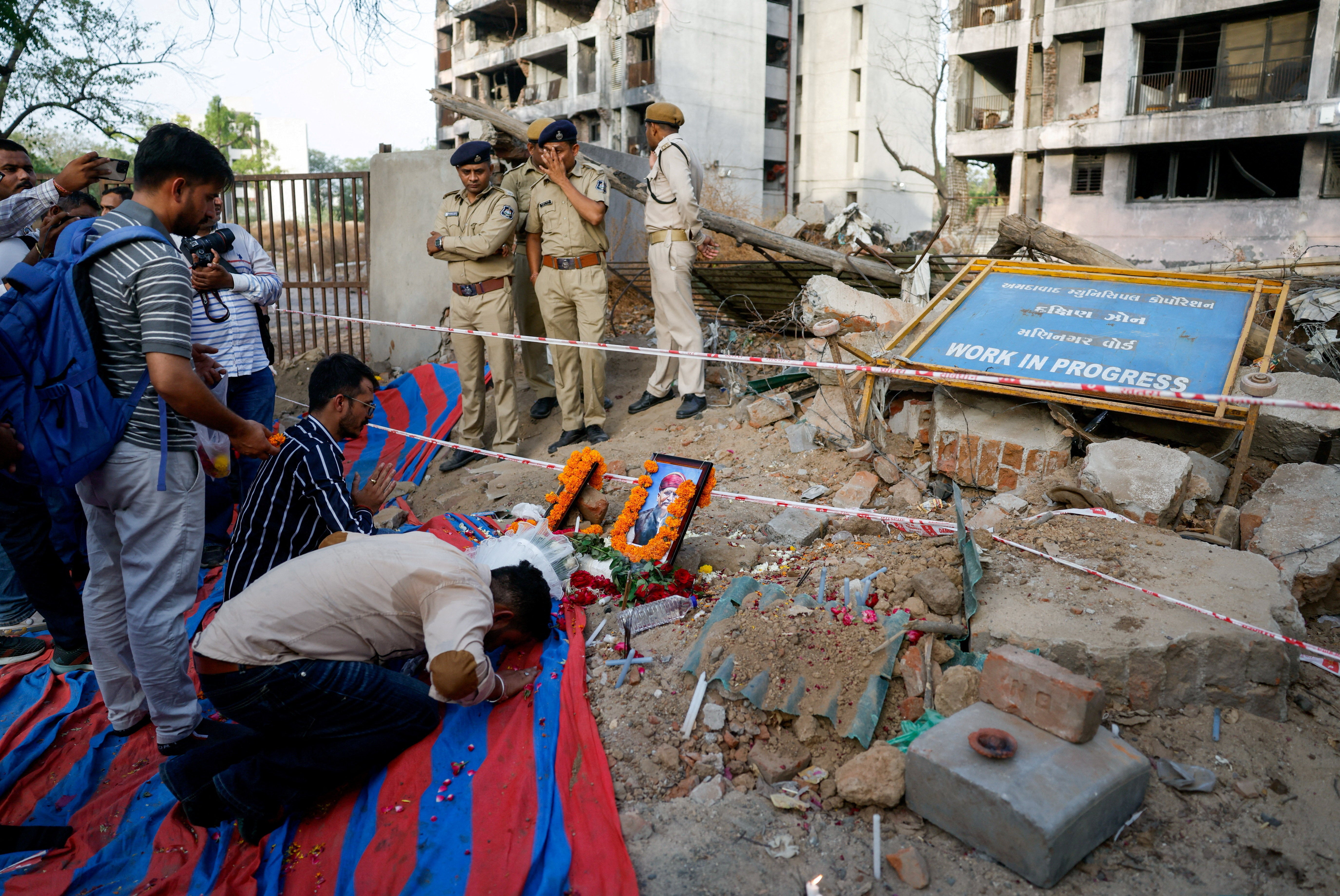 A family member prays at the crash site during the first anniversary of the Air India Boeing 787-8 Dreamliner crash in Ahmedabad, India