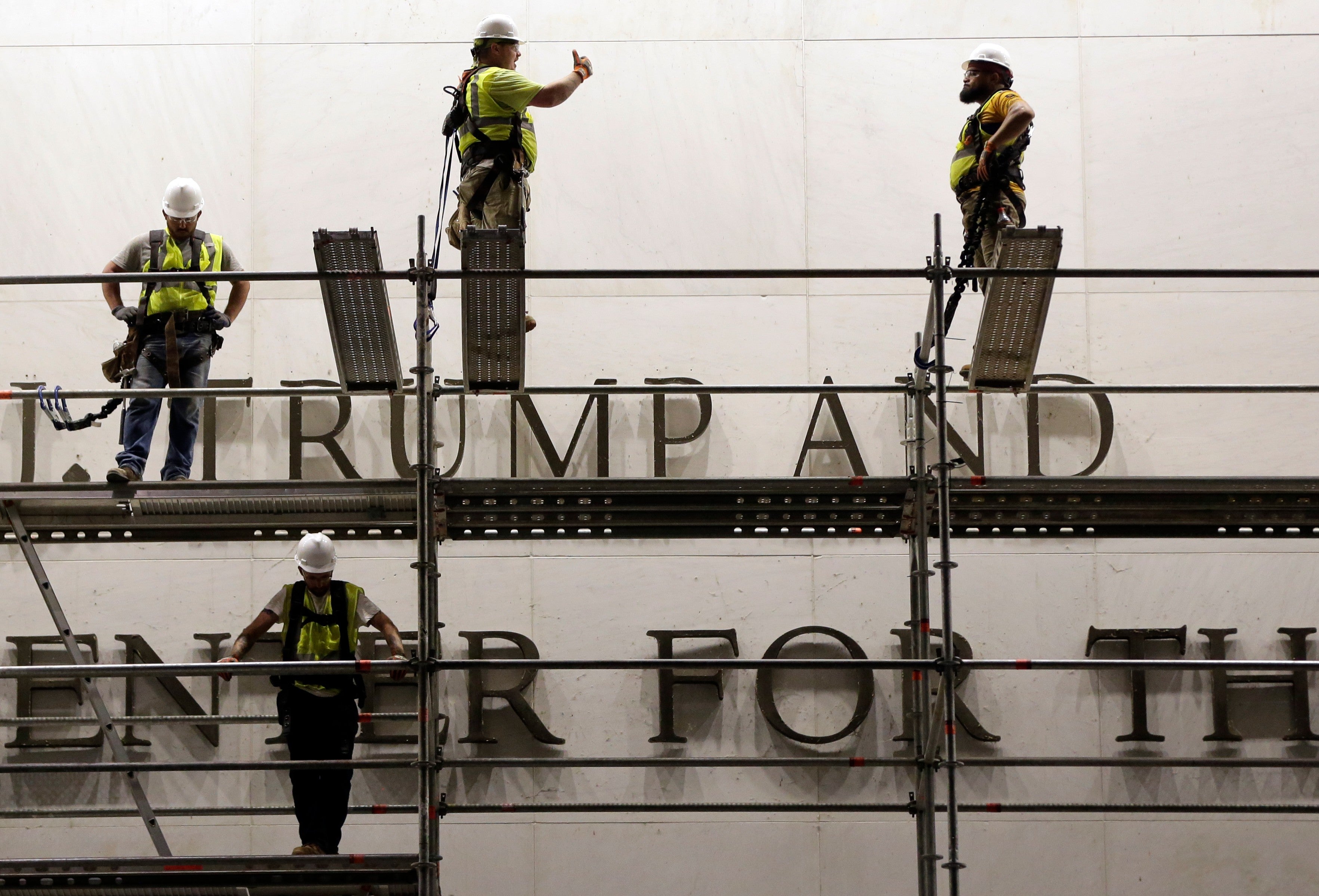 Workers prepare to remove Trump's name from the Kennedy Center, in photos
