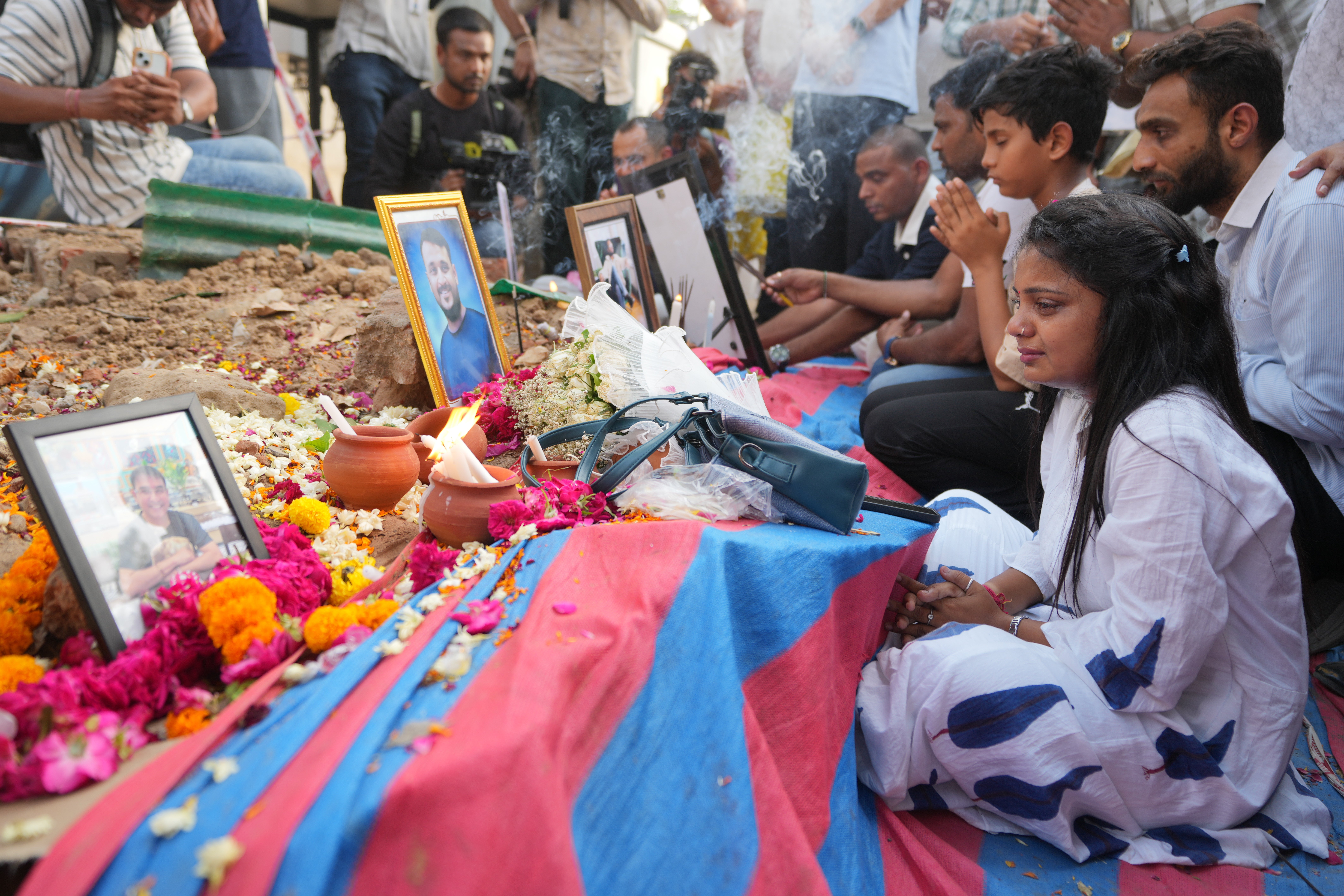 Family members of an Air India crash victims pay tribute at the crash site on the first anniversary of the tragedy, in Ahmedabad, India, Friday