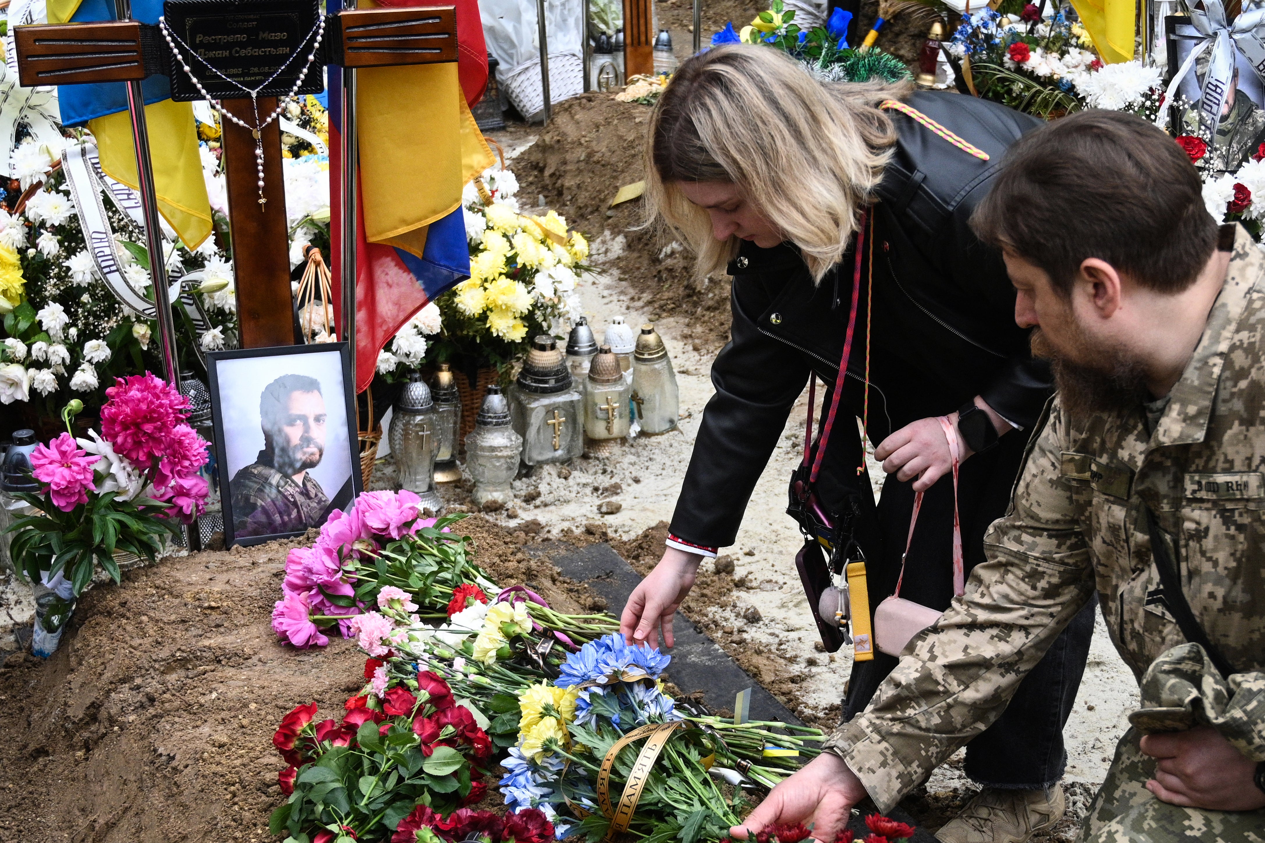 Mourners lay flowers at the grave of Colombian fighter Jhan Sebastian Restrepo Mazo (AFP/Getty)