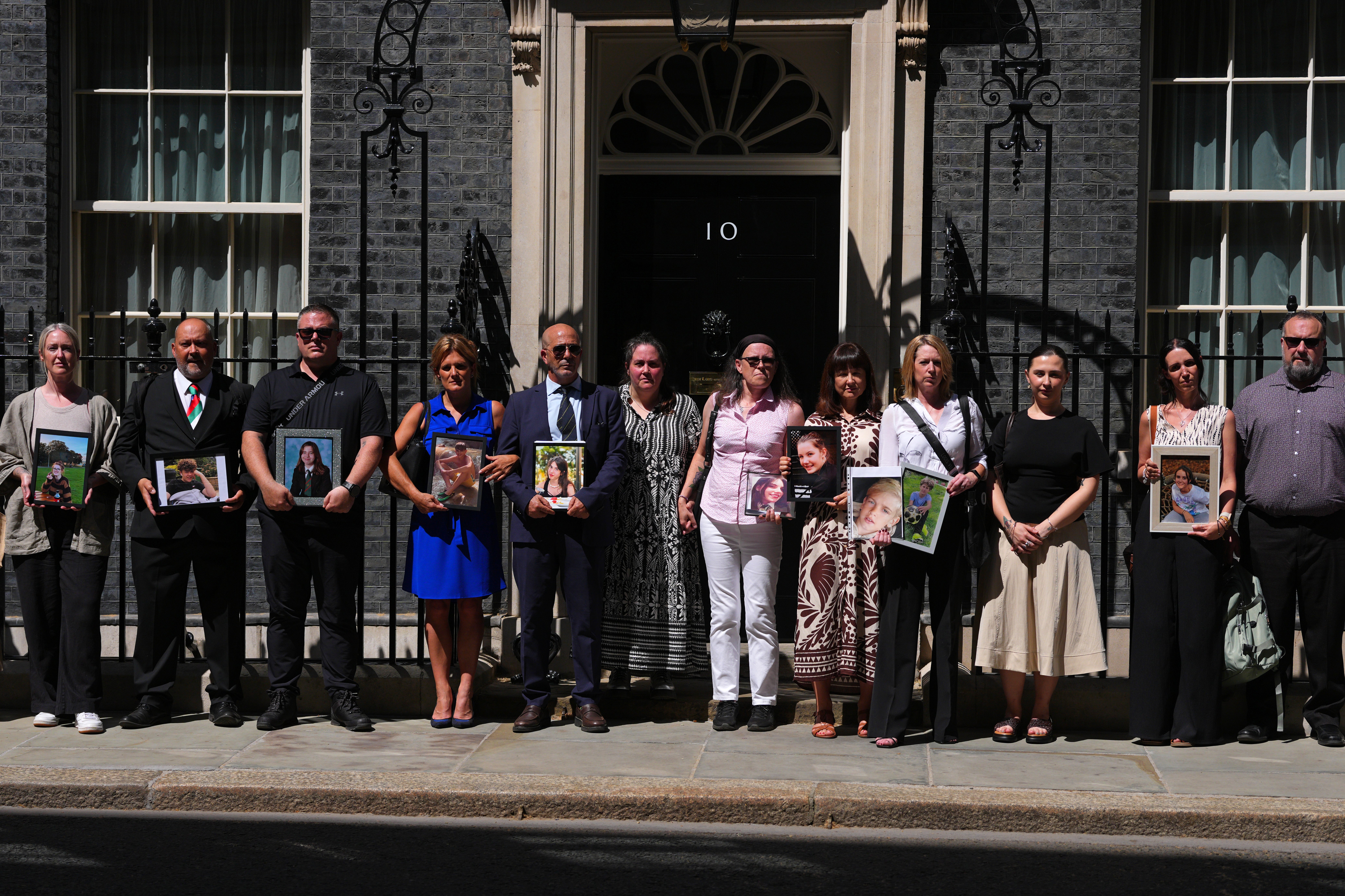 LONDOBereaved parents pose with images of their children outside Downing Street on May 26, 2026 in London, England