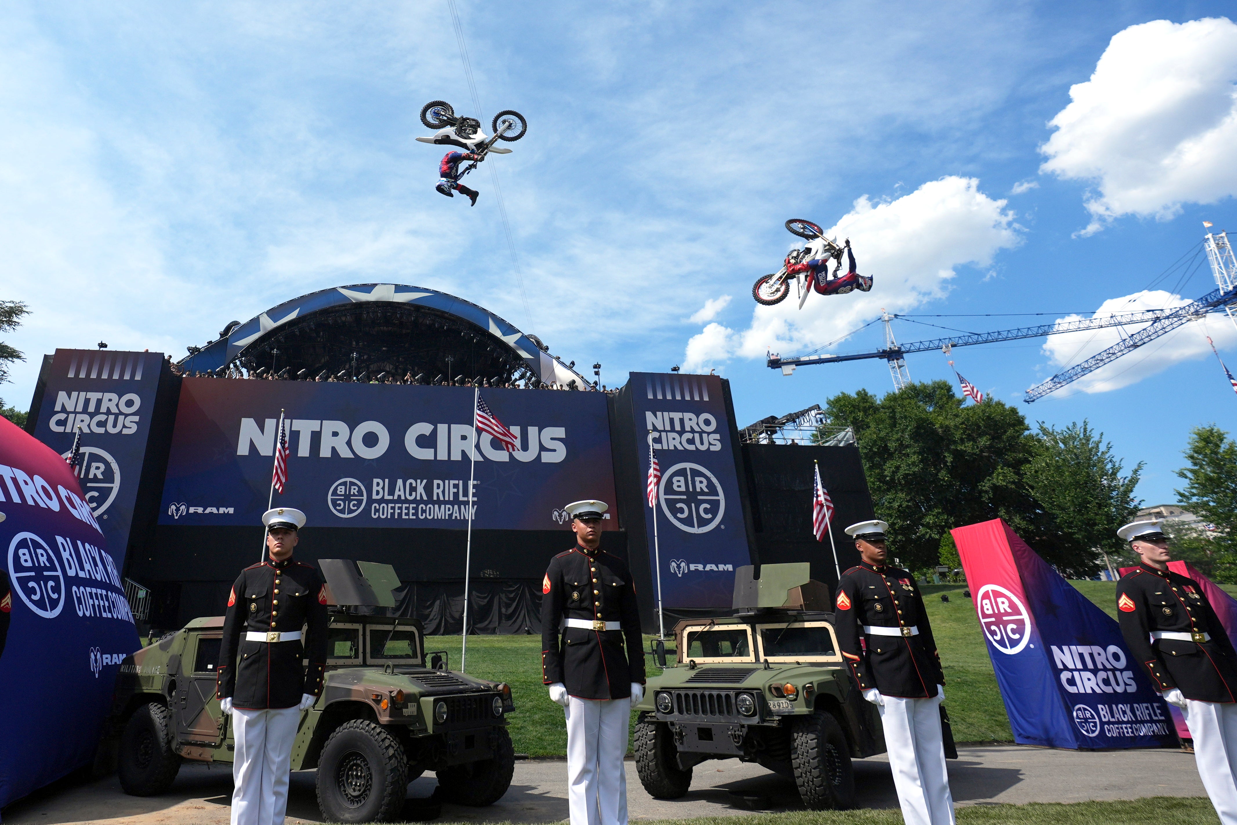 Athletes are seen soaring through the air while US service members stand at attention in the foreground (Getty Images)