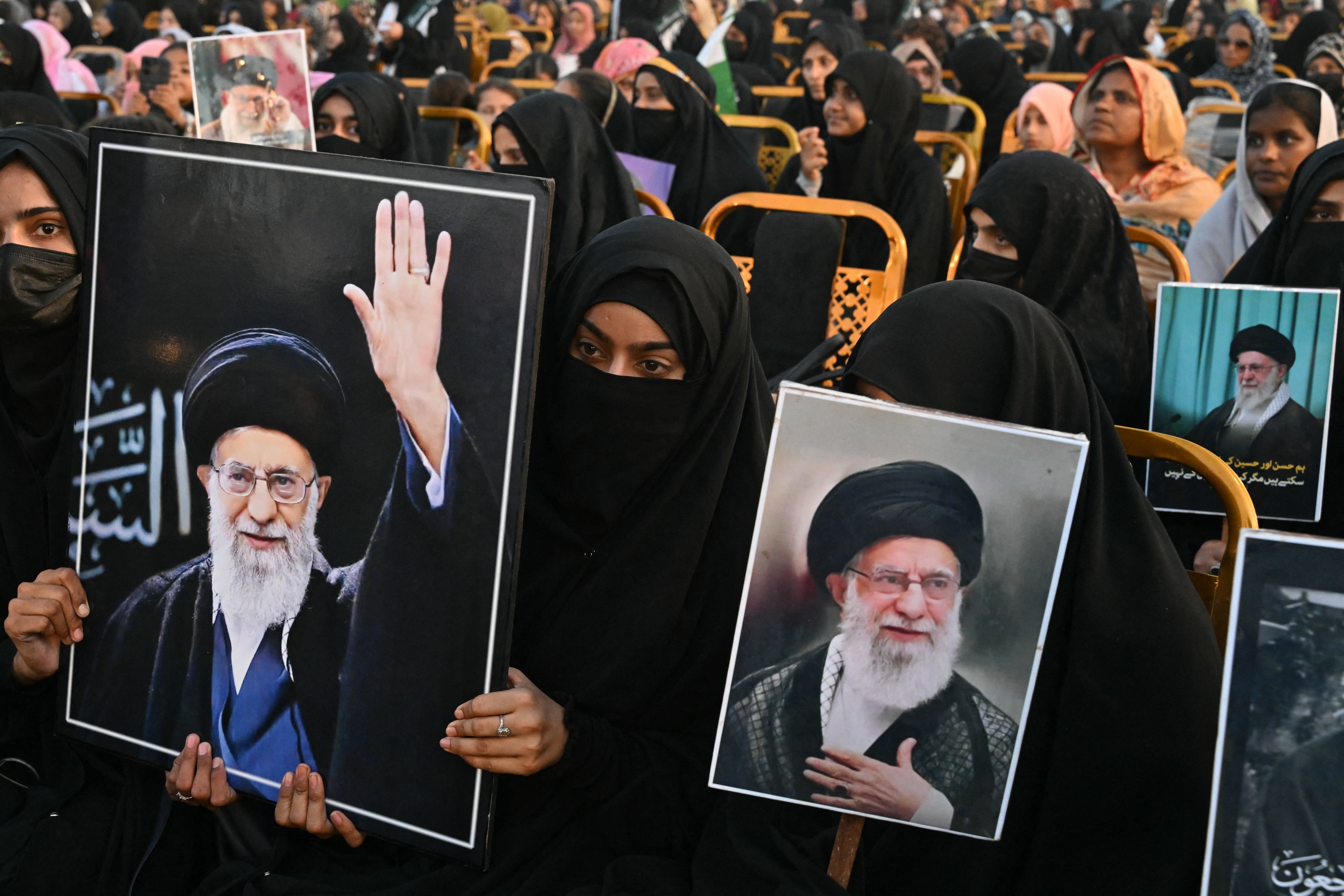 Activists carry portraits of Iran's slain supreme leader Ayatollah Ali Khamenei, as they pay tribute at Minar-e-Pakistan in Lahore