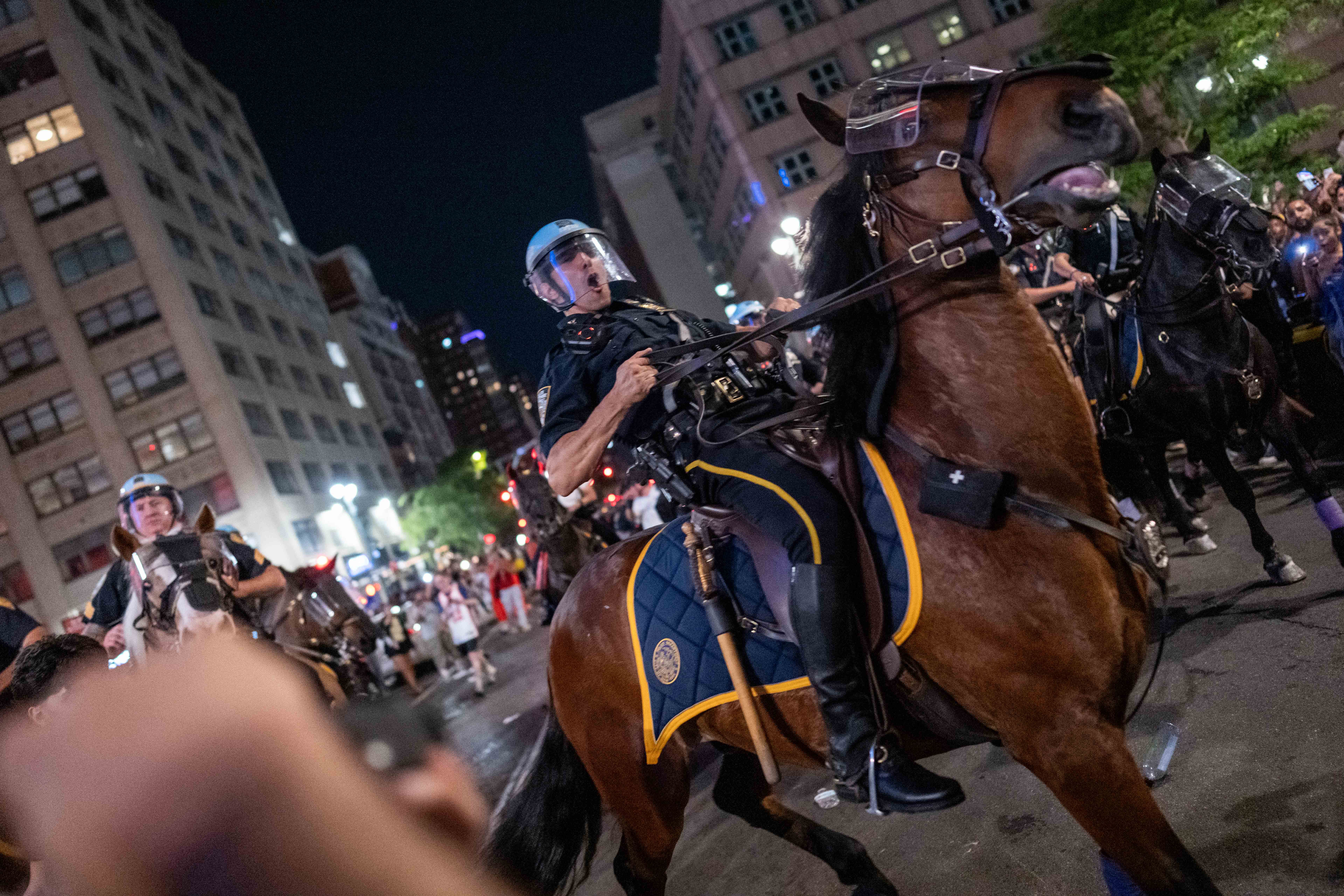 : NYPD Mounted Unit move back New York Knicks fans as they celebrate their win against San Antonio Spurs in Game 5 of the NBA Finals on June 13, 2026 in New York City