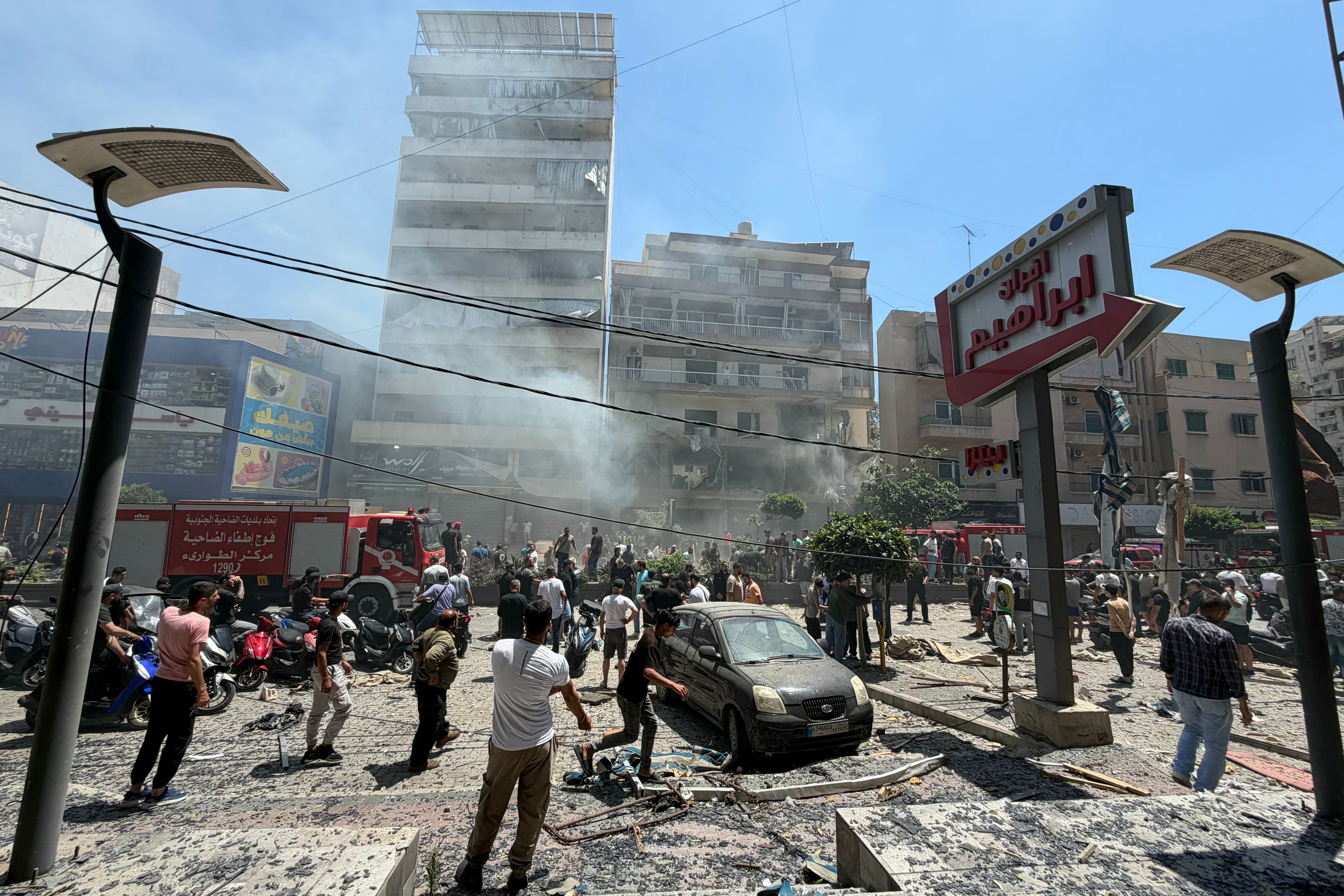 People gather at the site of an Israeli airstrike that targeted a building in Beirut's southern suburbs