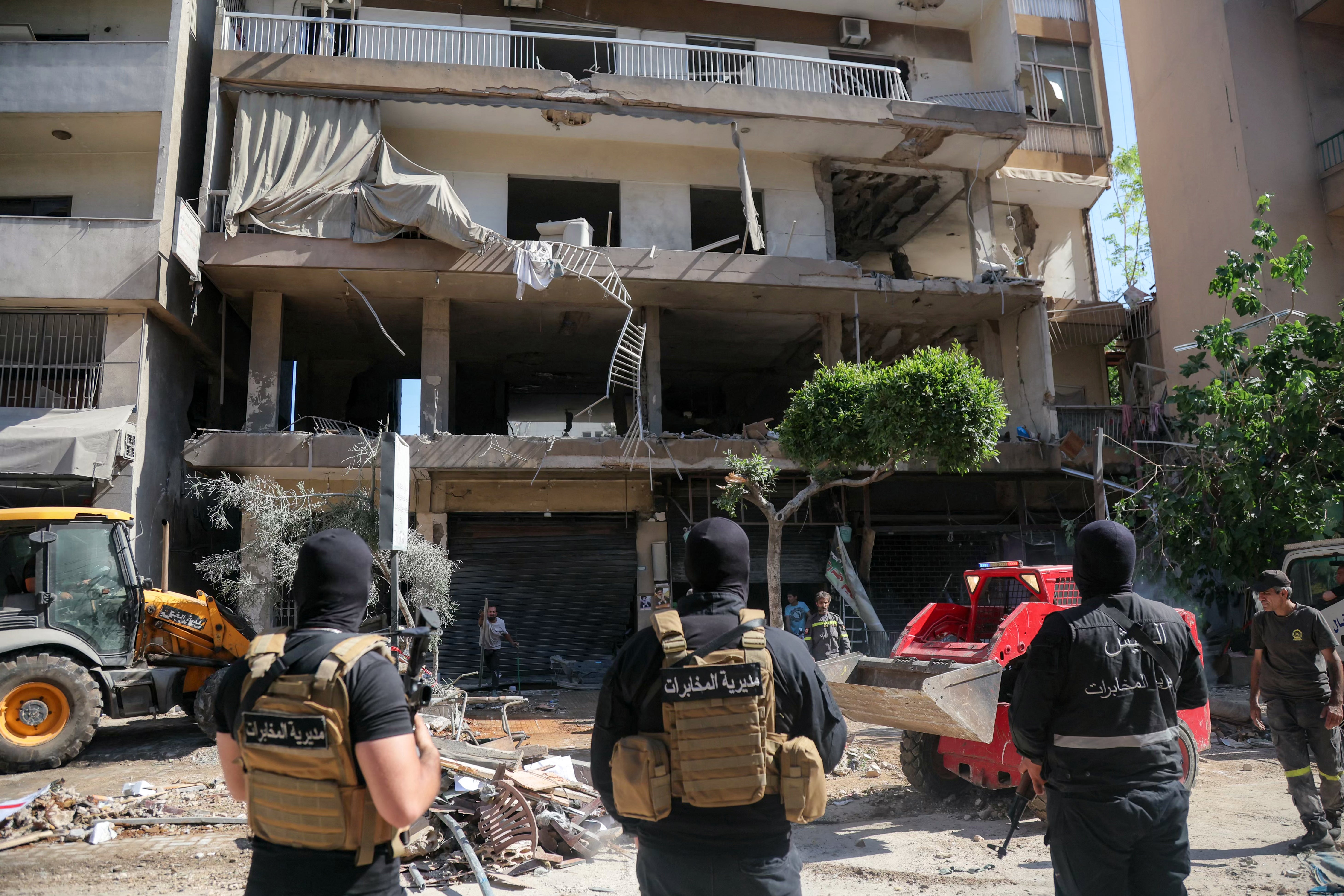 Lebanese army soldiers stand guard as people clear the rubble at the site of an Israeli airstrike that targeted a building in Beirut's southern suburbs on June 14, 2026