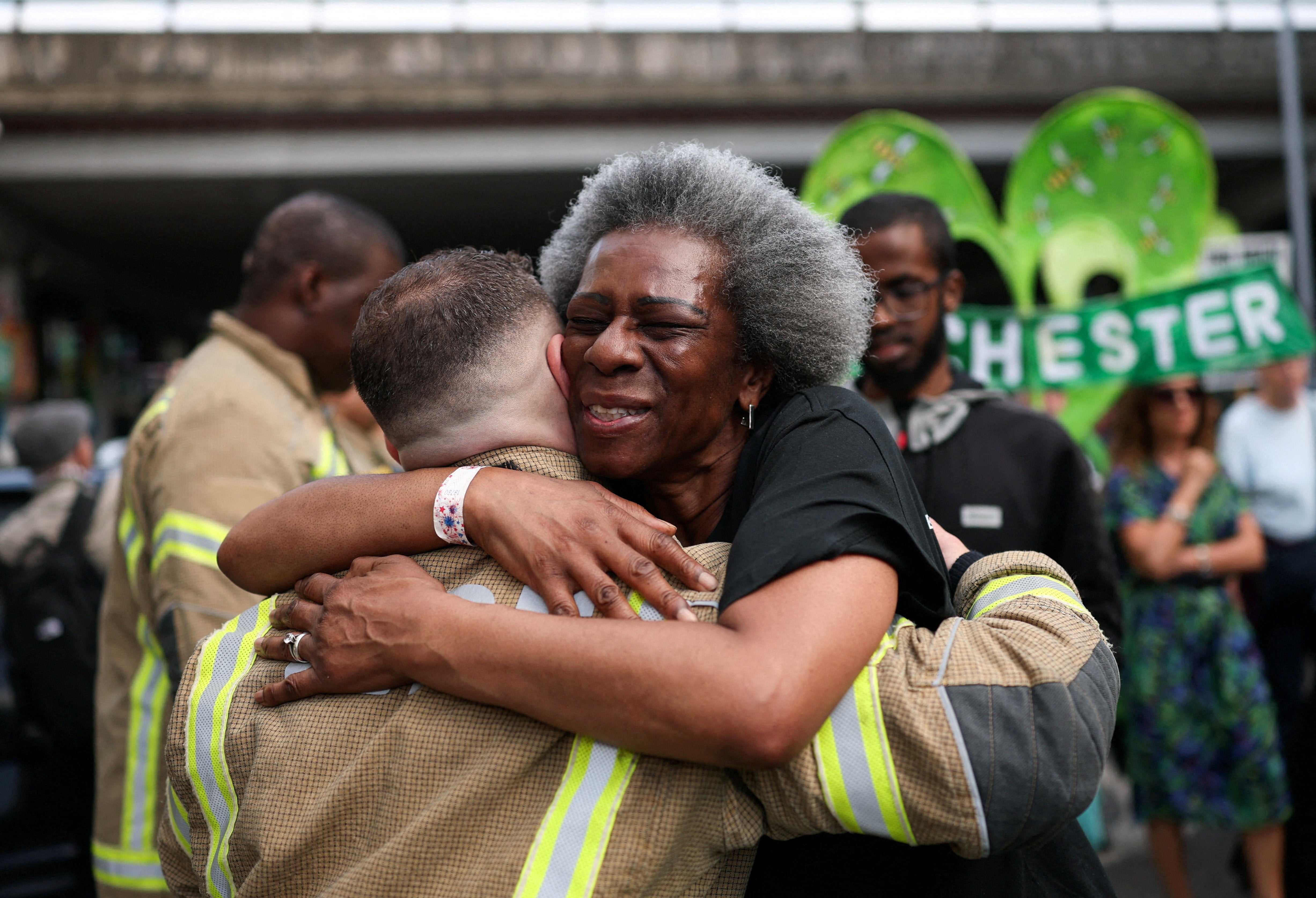 Grenfell survivors embrace firefighters at emotional anniversary march