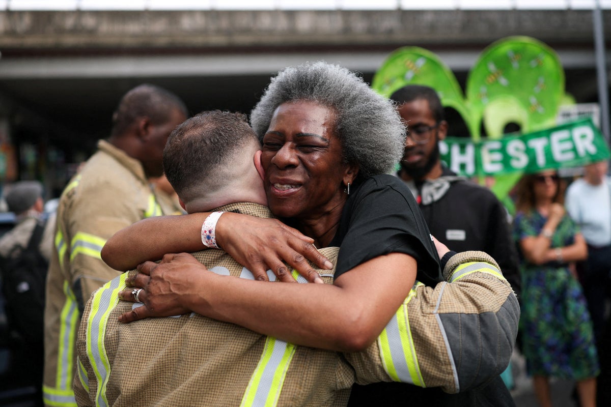 Grenfell survivors embrace firefighters at emotional anniversary march