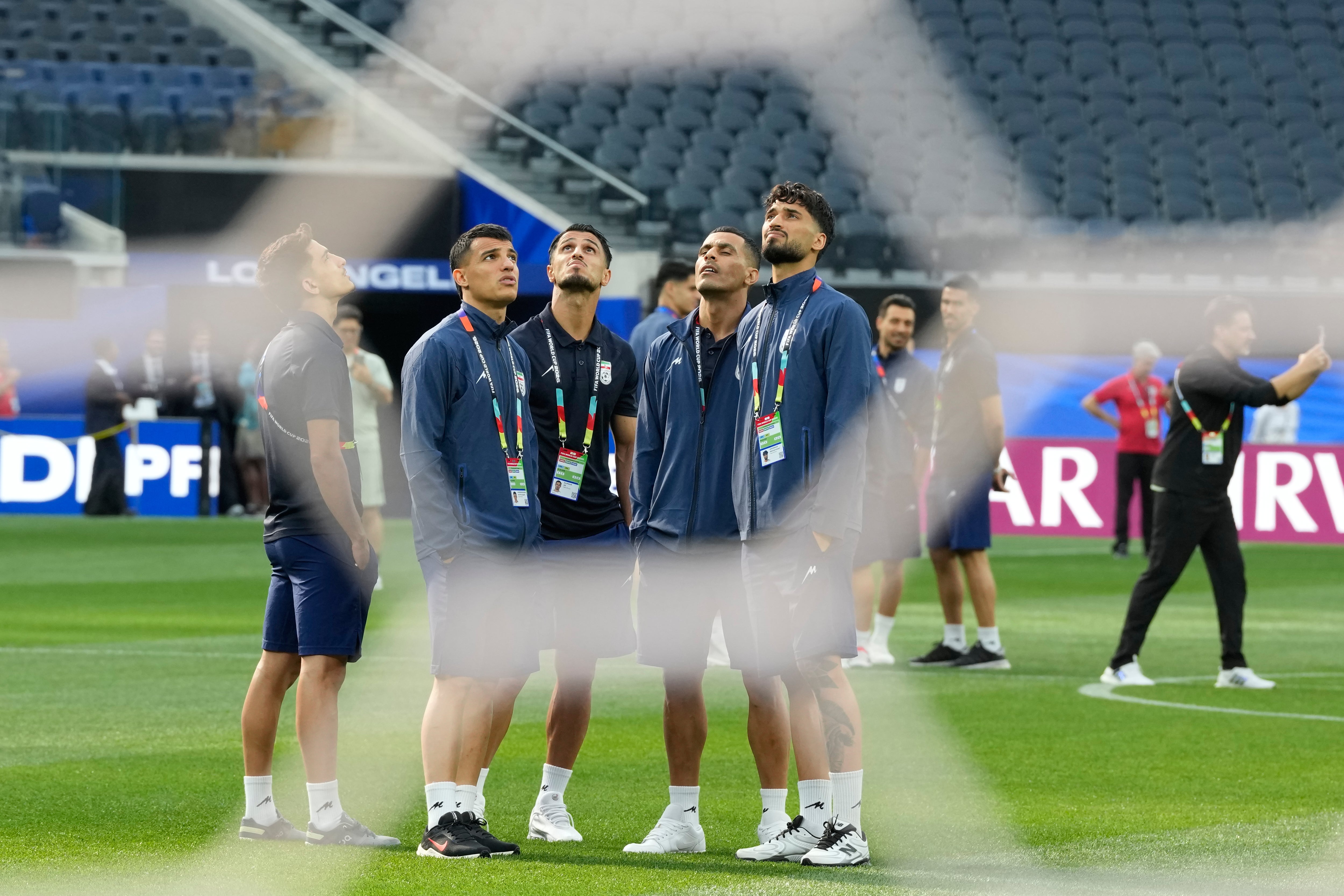 Iran players stand on the pitch at the stadium (AP)