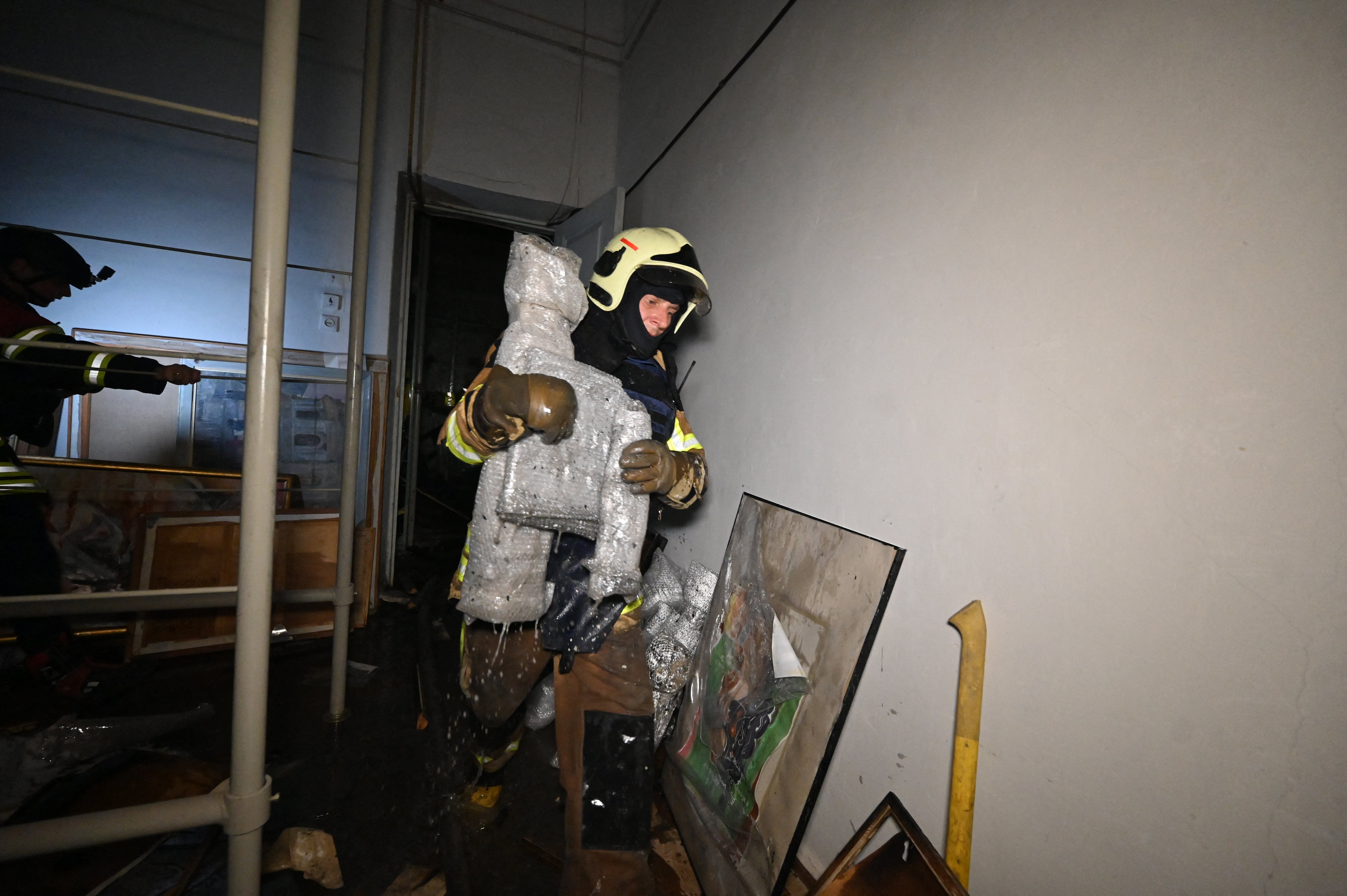 A firefighter walks past damaged paintings at the damaged Kharkiv Art Museum following a drone strike in Kharkiv (AFP/Getty)