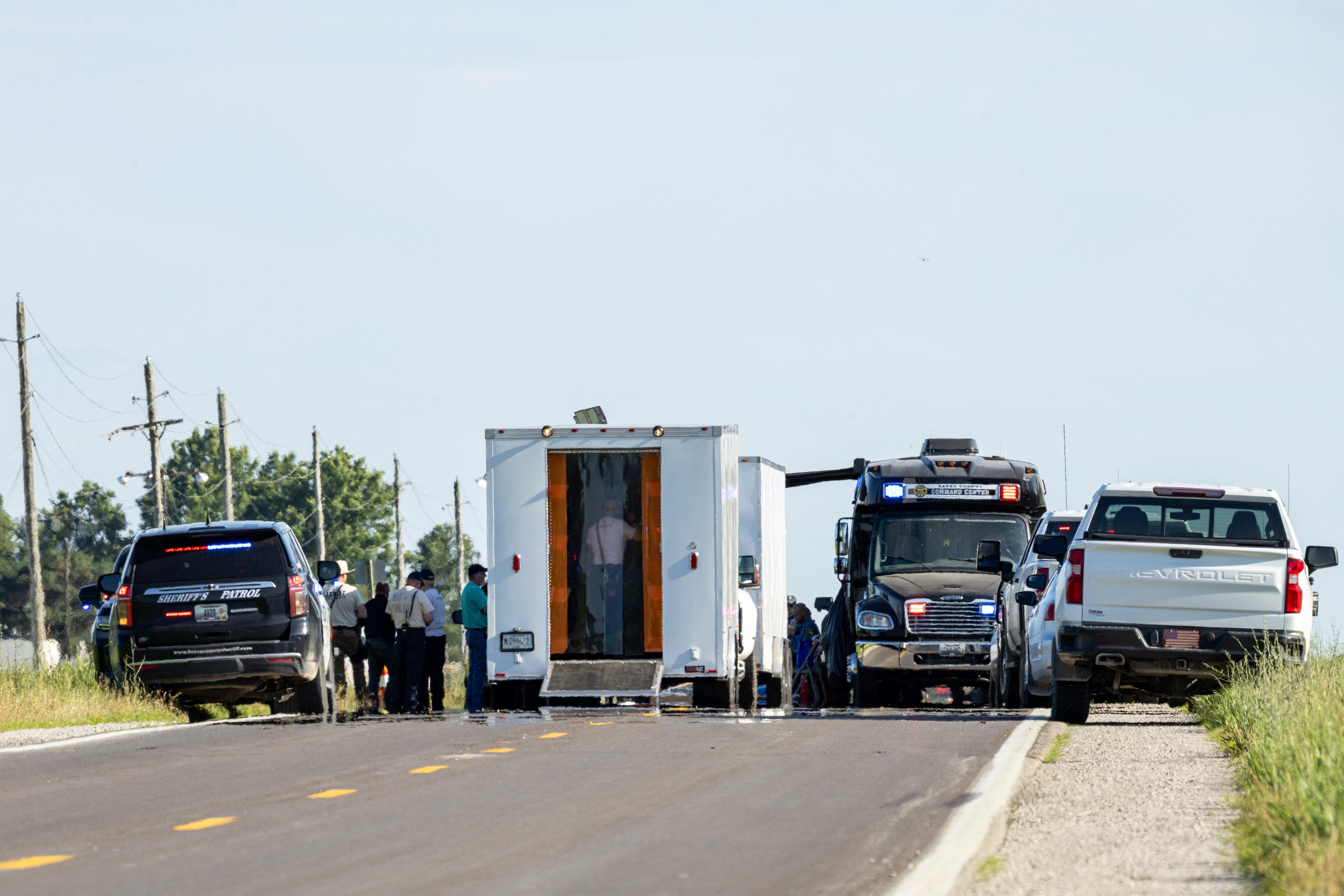 Bates County Command Center vehicles block the road near the scene of a fatal skydiving plane crash near Butler Memorial Airport