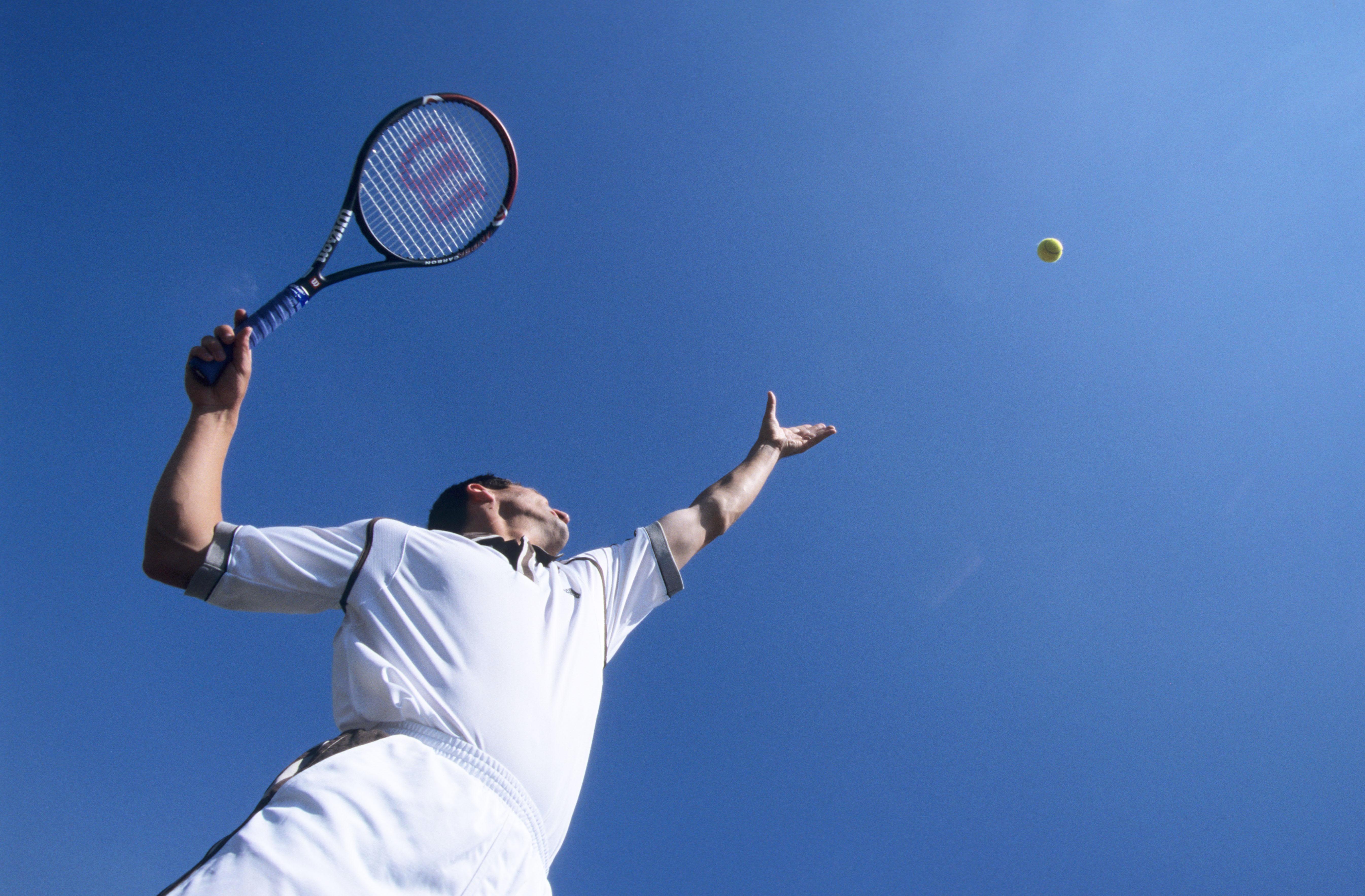 Man throwing a tennis ball in the air during his serve (Alamy/PA)