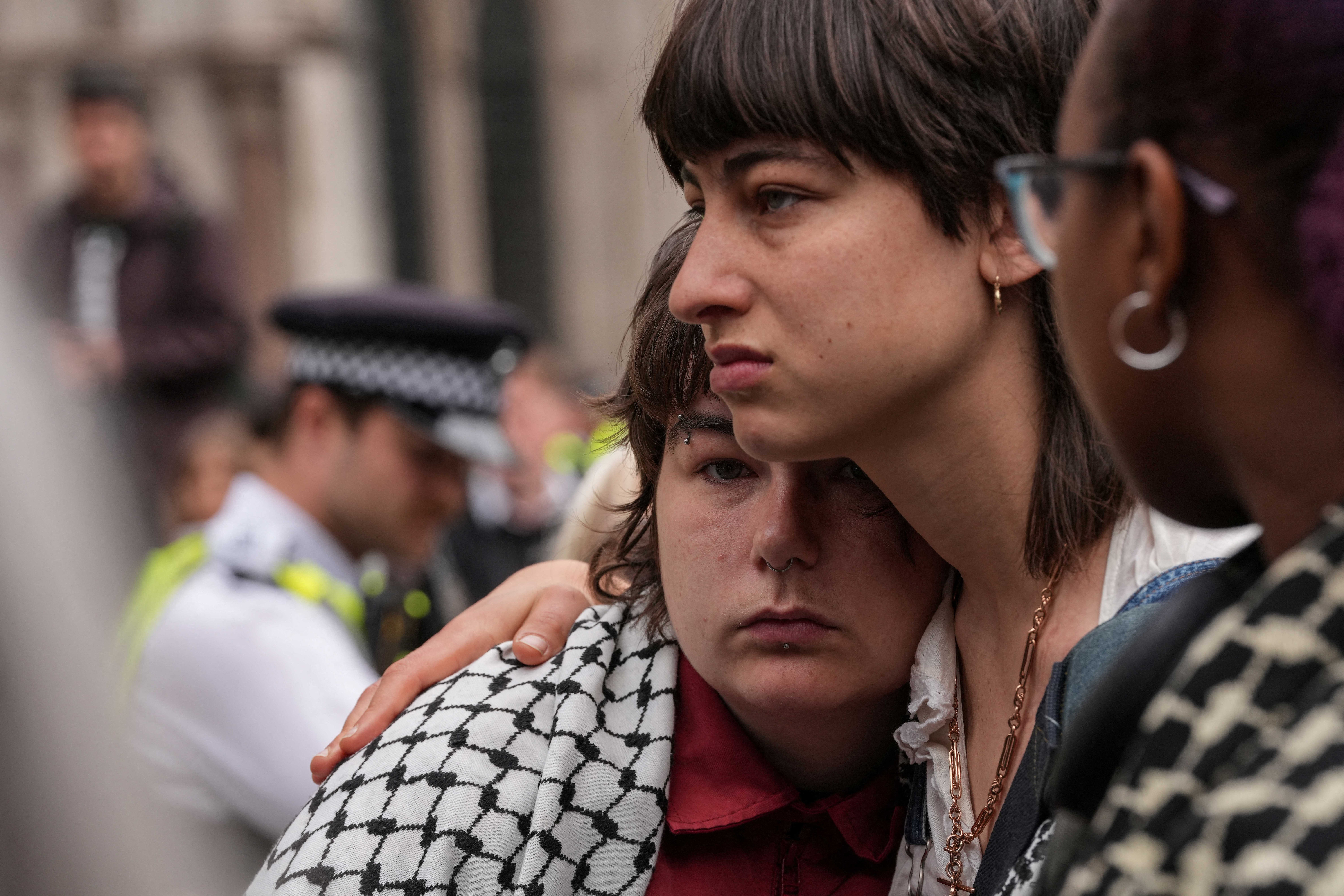 People react as they listen to the court proceedings outside the Royal Courts of Justice
