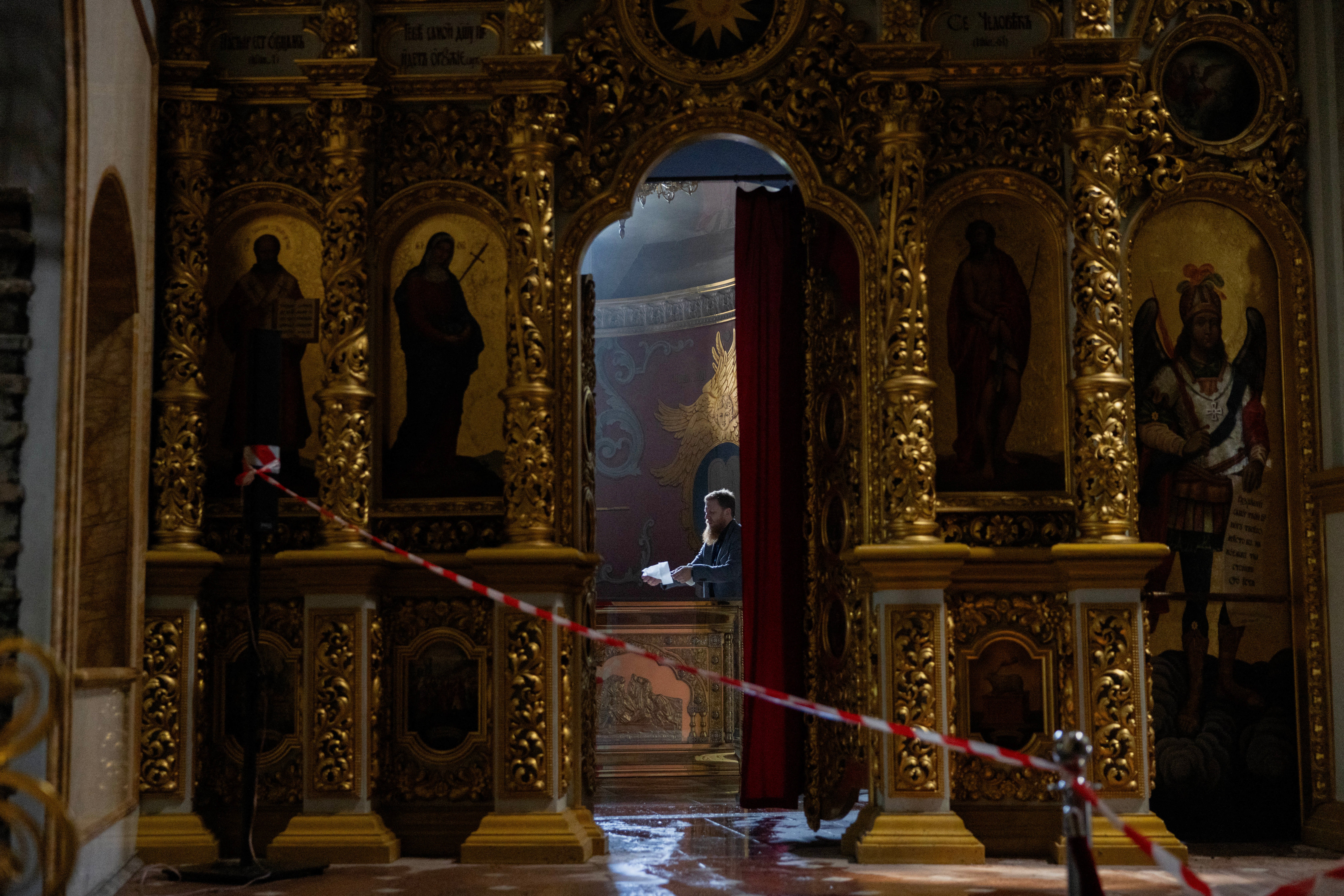 A clergyman is cleaning in the damaged Dormition Cathedral in the Orthodox complex of the Kyiv Pechersk Lavra following a Russian missile and drone strike in Kyiv on June 15, 2026, amid the Russian invasion of Ukraine. (AFP/Getty)