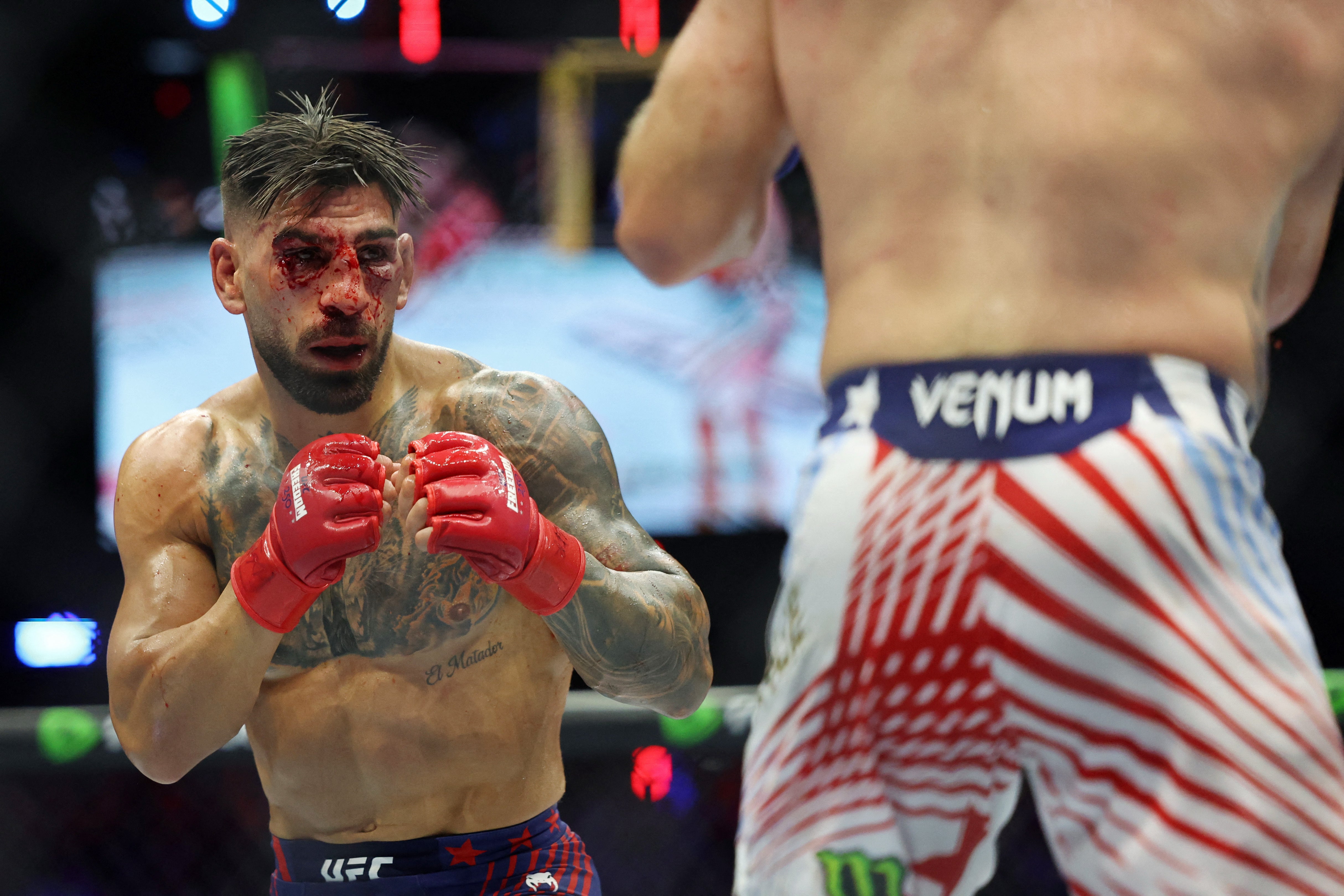 Ilia Topuria (red gloves) was battered early by Justin Gaethje during UFC Freedom 250 on the White House South Lawn and could barely see through the blood and swelling before the fight was called (Reuters)